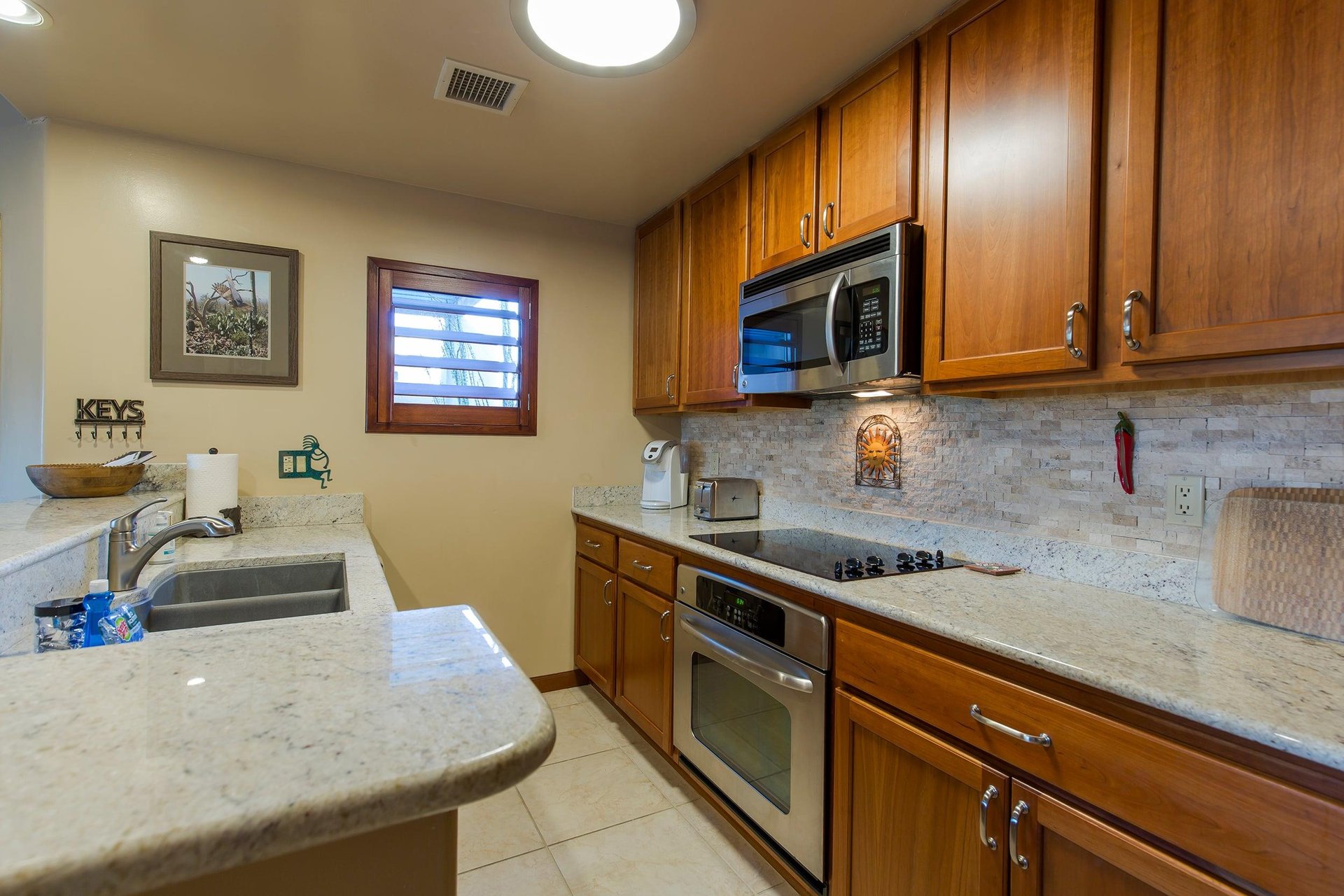 Features bartop counter seating for 2 guests, stainless steel appliances, keurig coffee maker, and kitchen essentials.