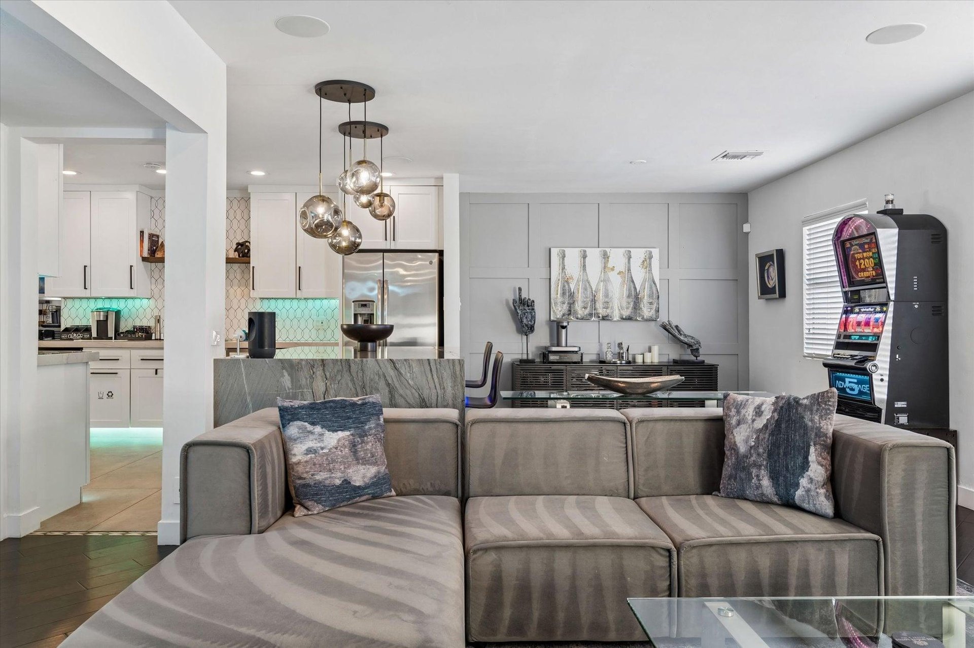 Views of the kitchen and incredible slot machine can be seen behind the living room area.