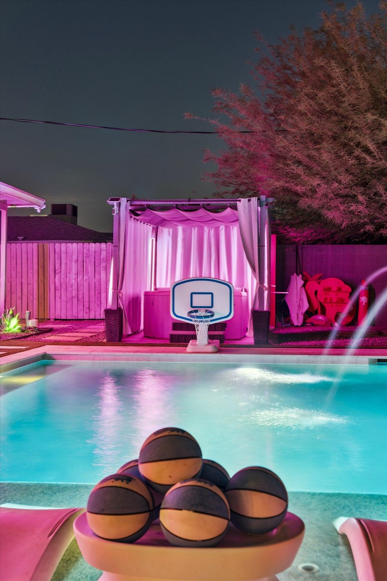 View of basketball hoop and hot tub with cabana.