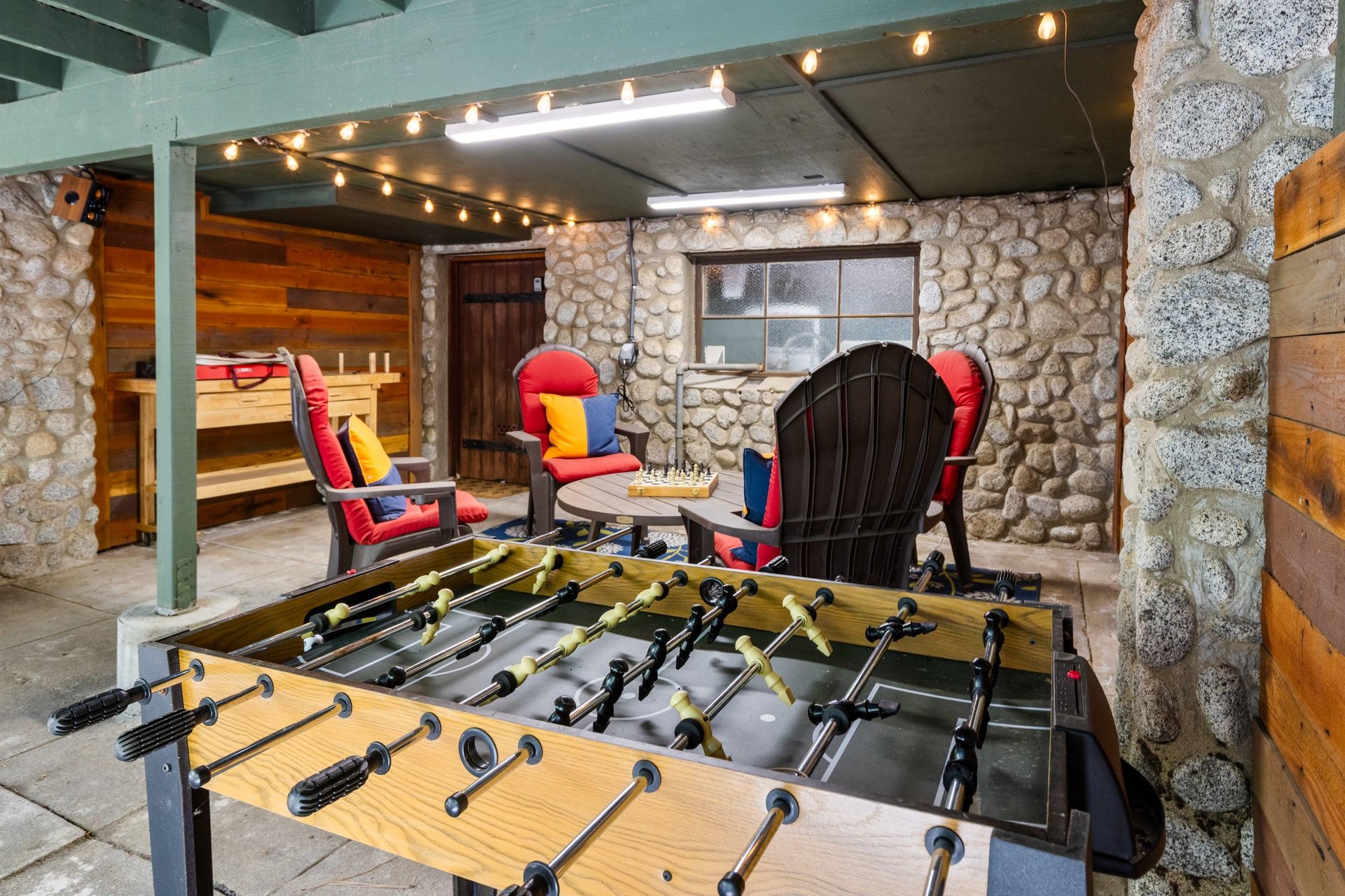 Below the deck is another outdoor seating area with games.