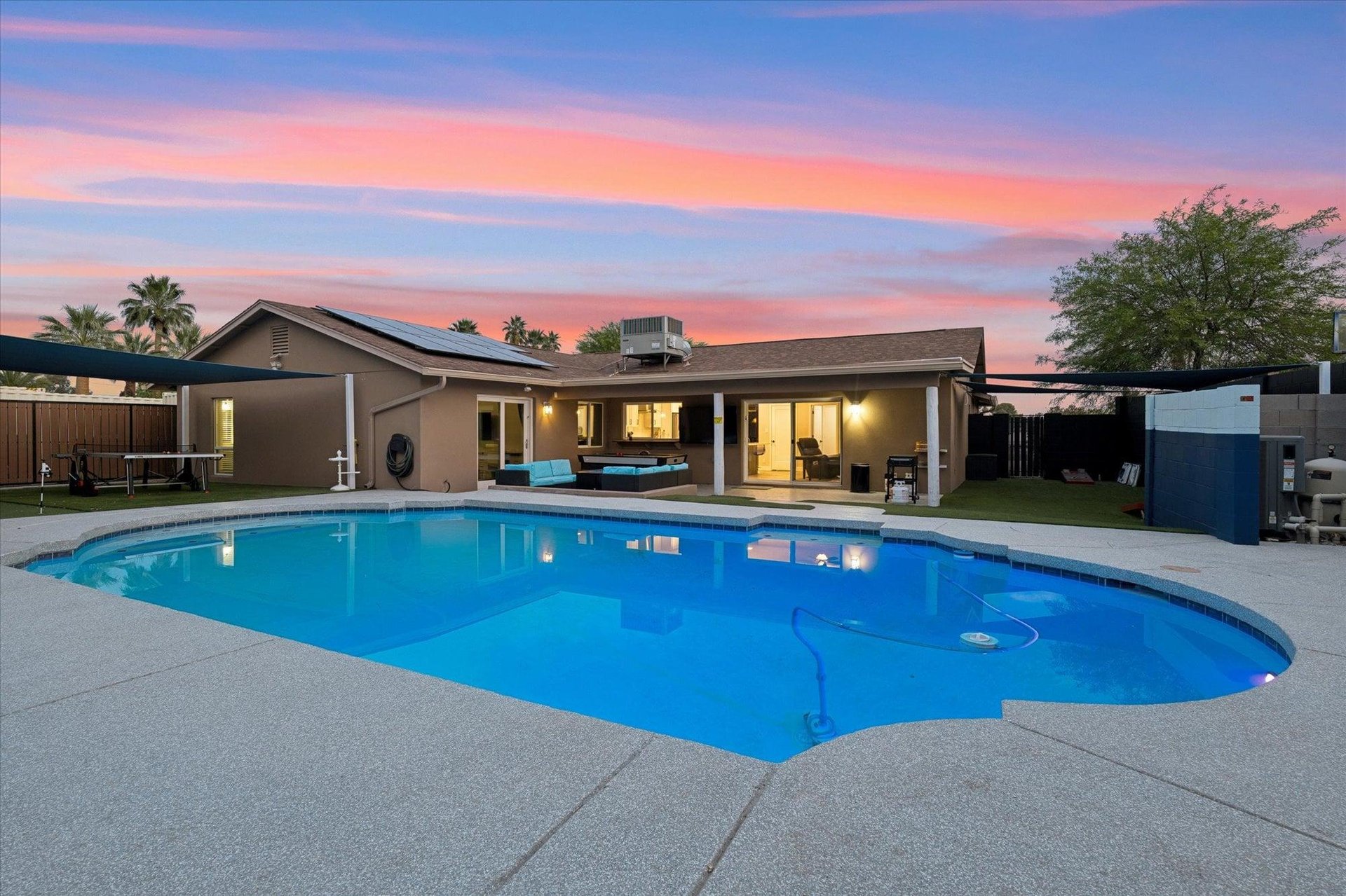 Complete with a fenced yard, private pool, covered patio, grill, firepit, cornhole, air hockey, pool table, mini golf putting green, and ping pong table.