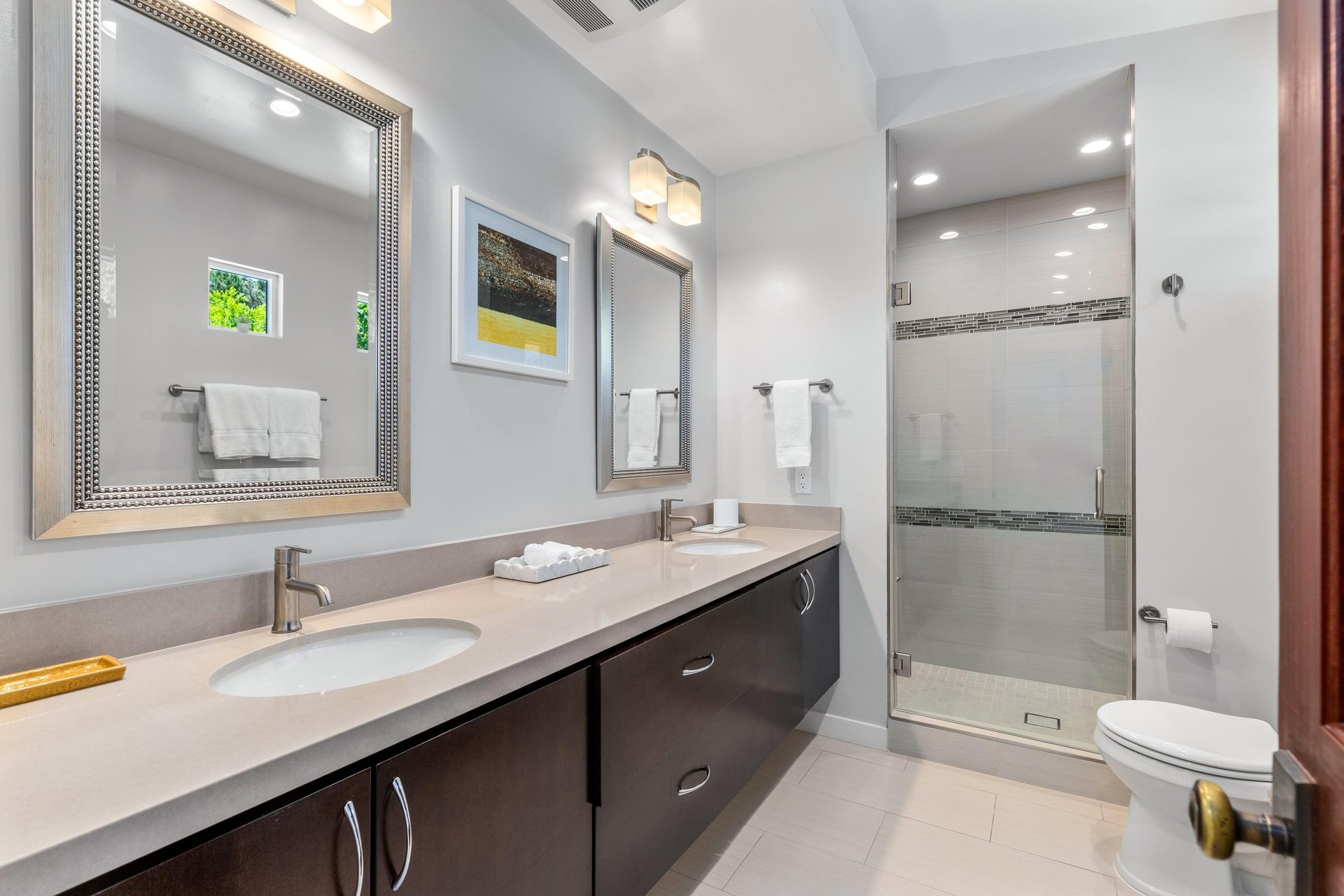 Ensuite bathroom with dual vanity sink, walkin closet, and standalone shower.
