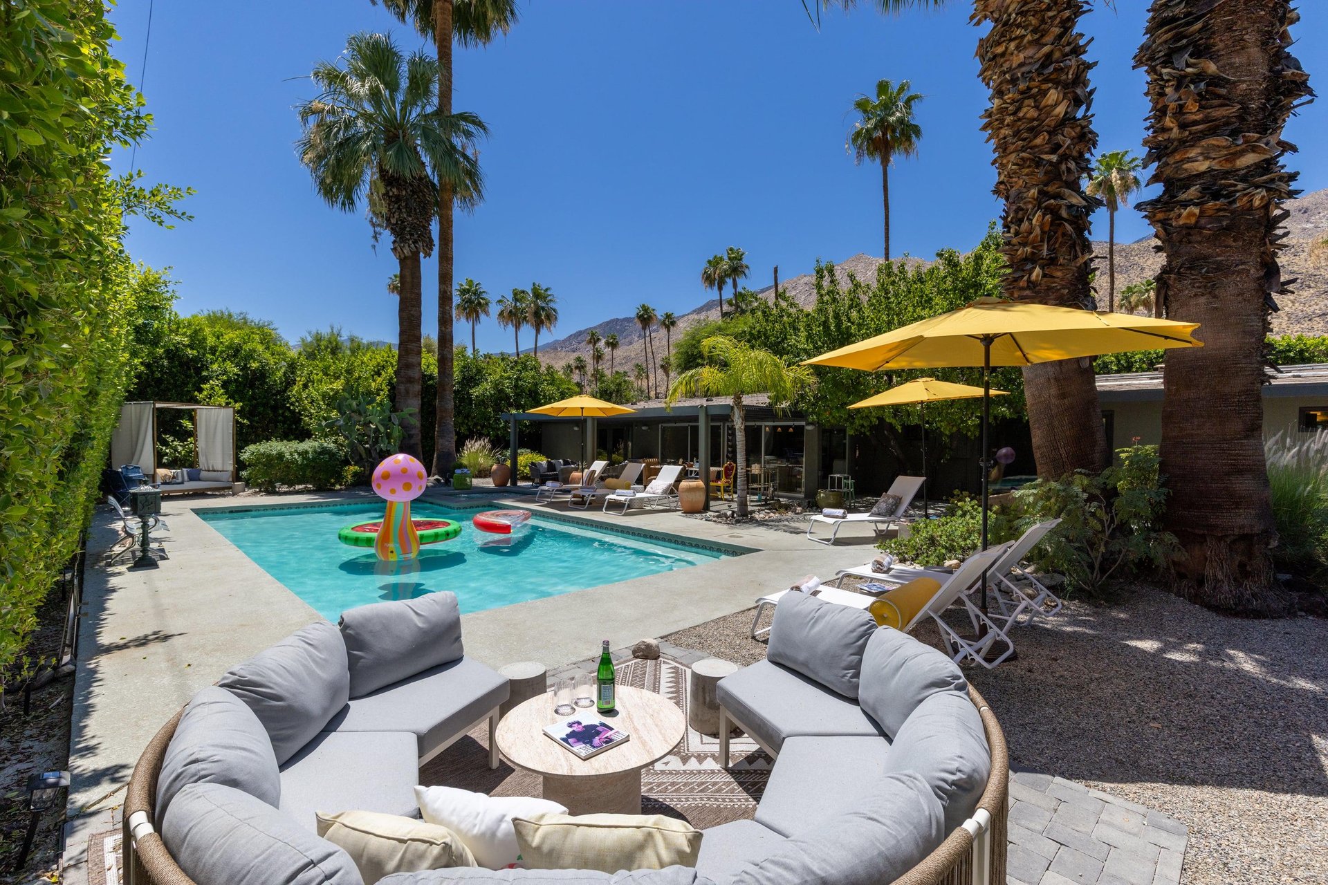 Entertainers backyard with outdoor seating, private pool and spa, sun loungers, cabana, and outdoor dining space.