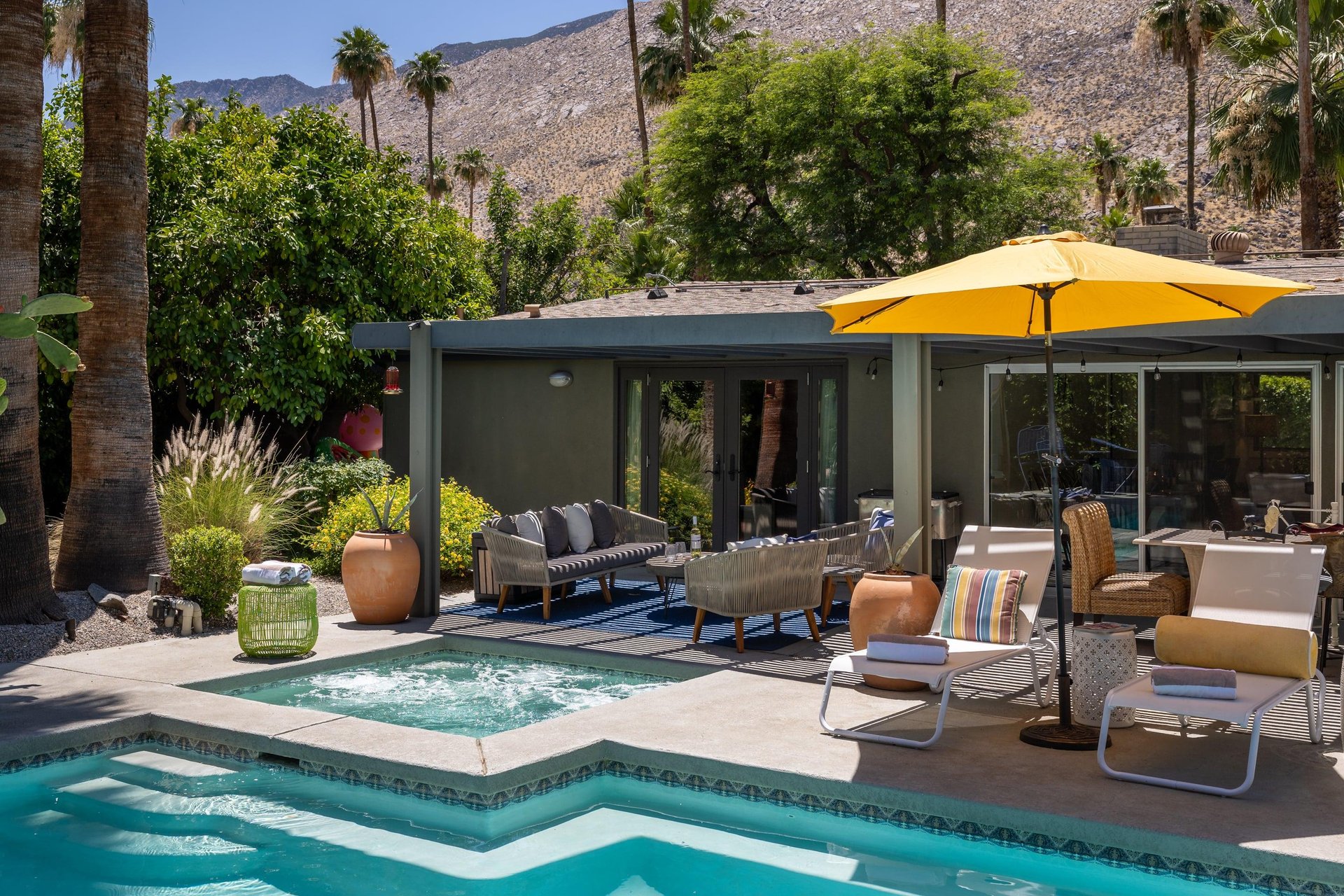 Entertainers backyard with outdoor seating, private pool and spa, sun loungers, cabana, and outdoor dining space.
