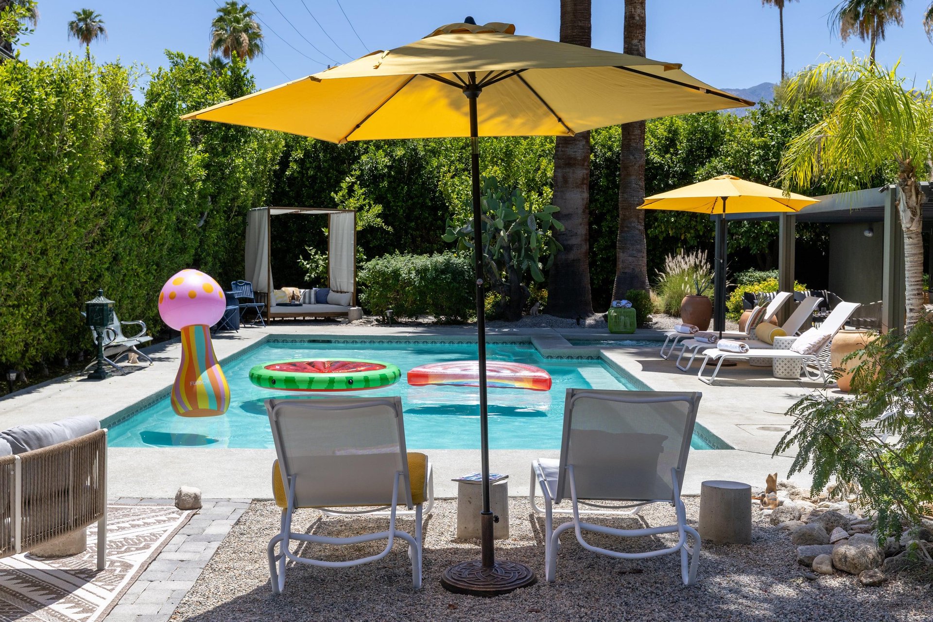 Entertainers backyard with outdoor seating, private pool and spa, sun loungers, cabana, and outdoor dining space.