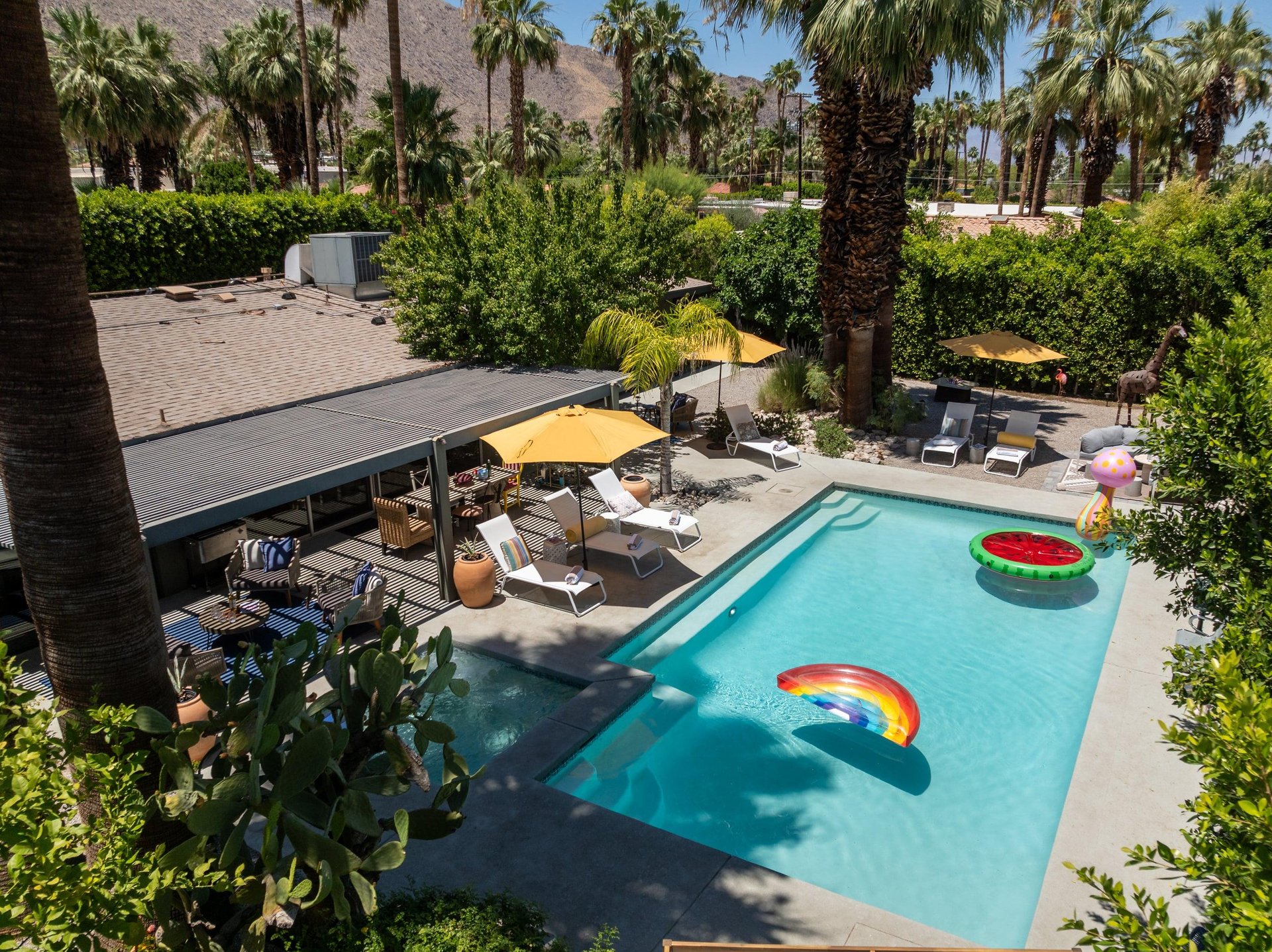 Entertainers backyard with outdoor seating, private pool and spa, sun loungers, cabana, and outdoor dining space.