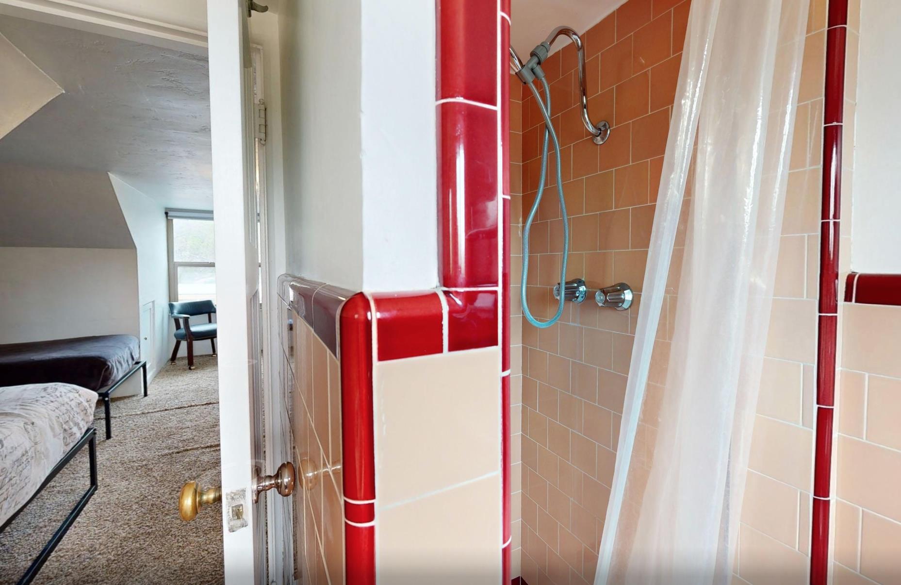 Full en suite bathroom with shower and detachable shower head.