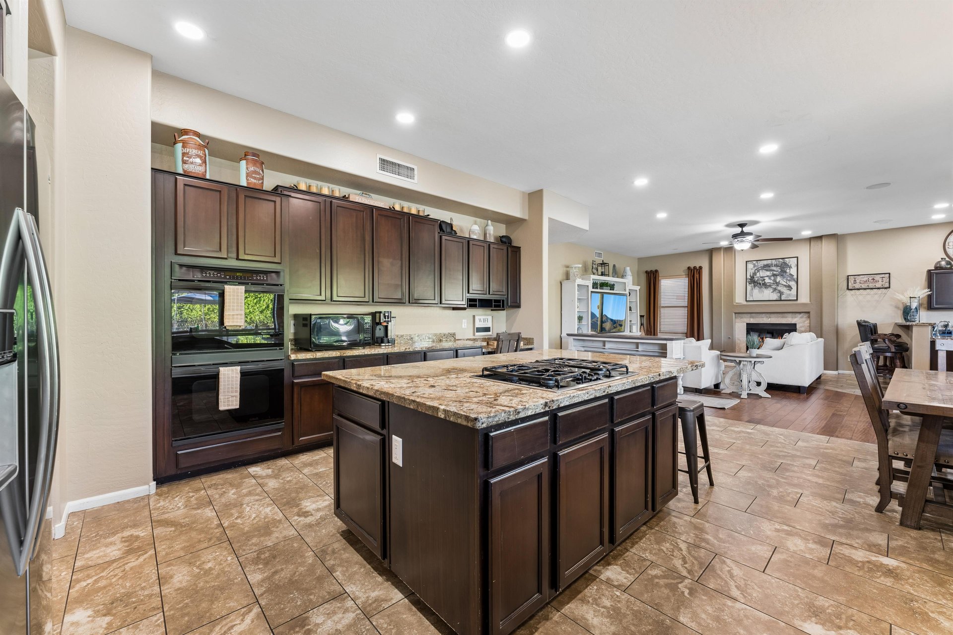 Chefs kitchen with large island, plenty of counter space, and stainless steel appliances.