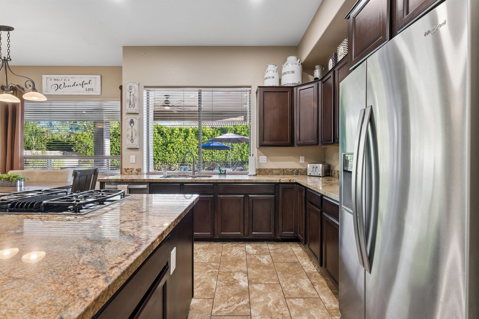 Chefs kitchen with large island, plenty of counter space, and stainless steel appliances.