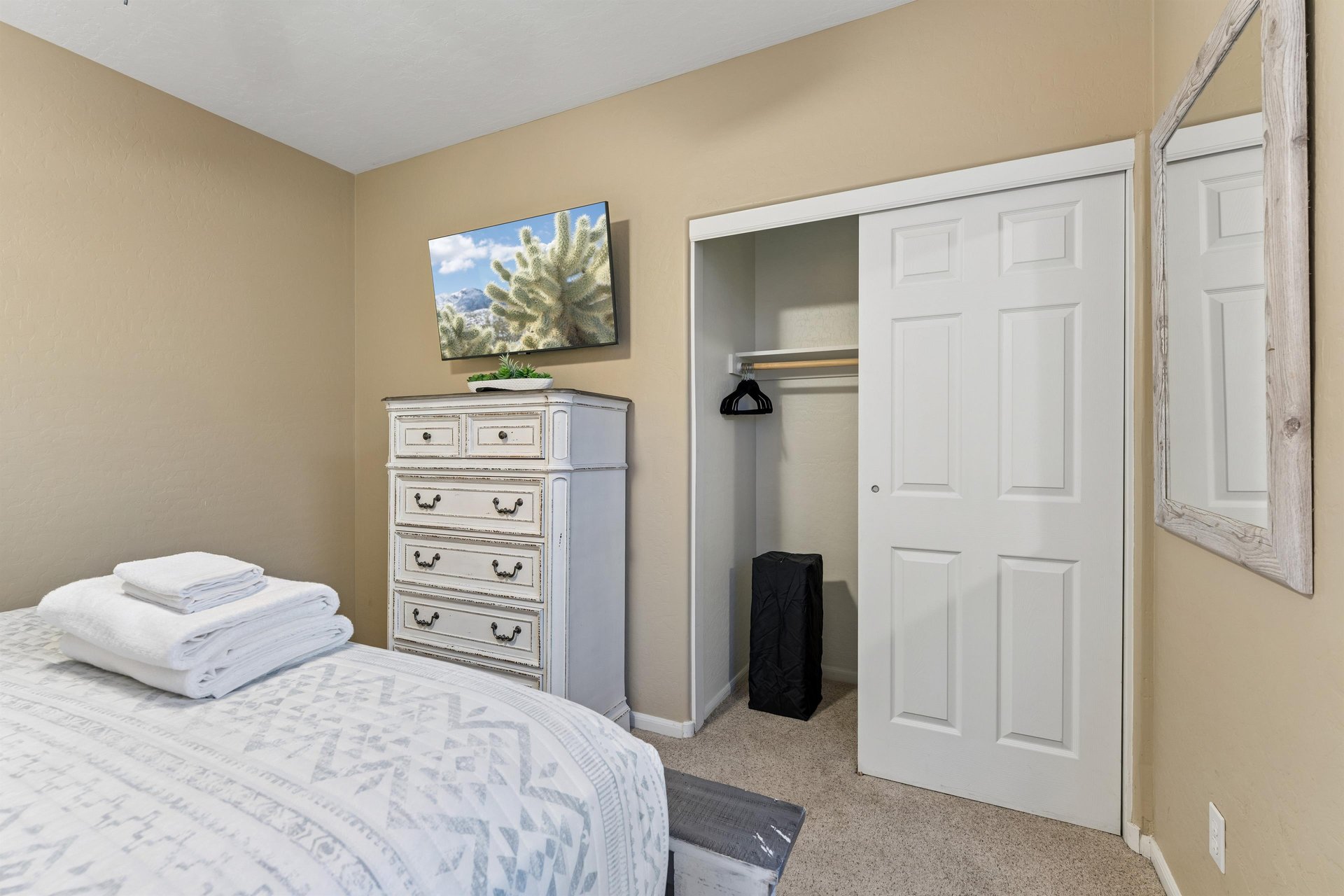 Queen size bed, flatscreen TV, and closet space.