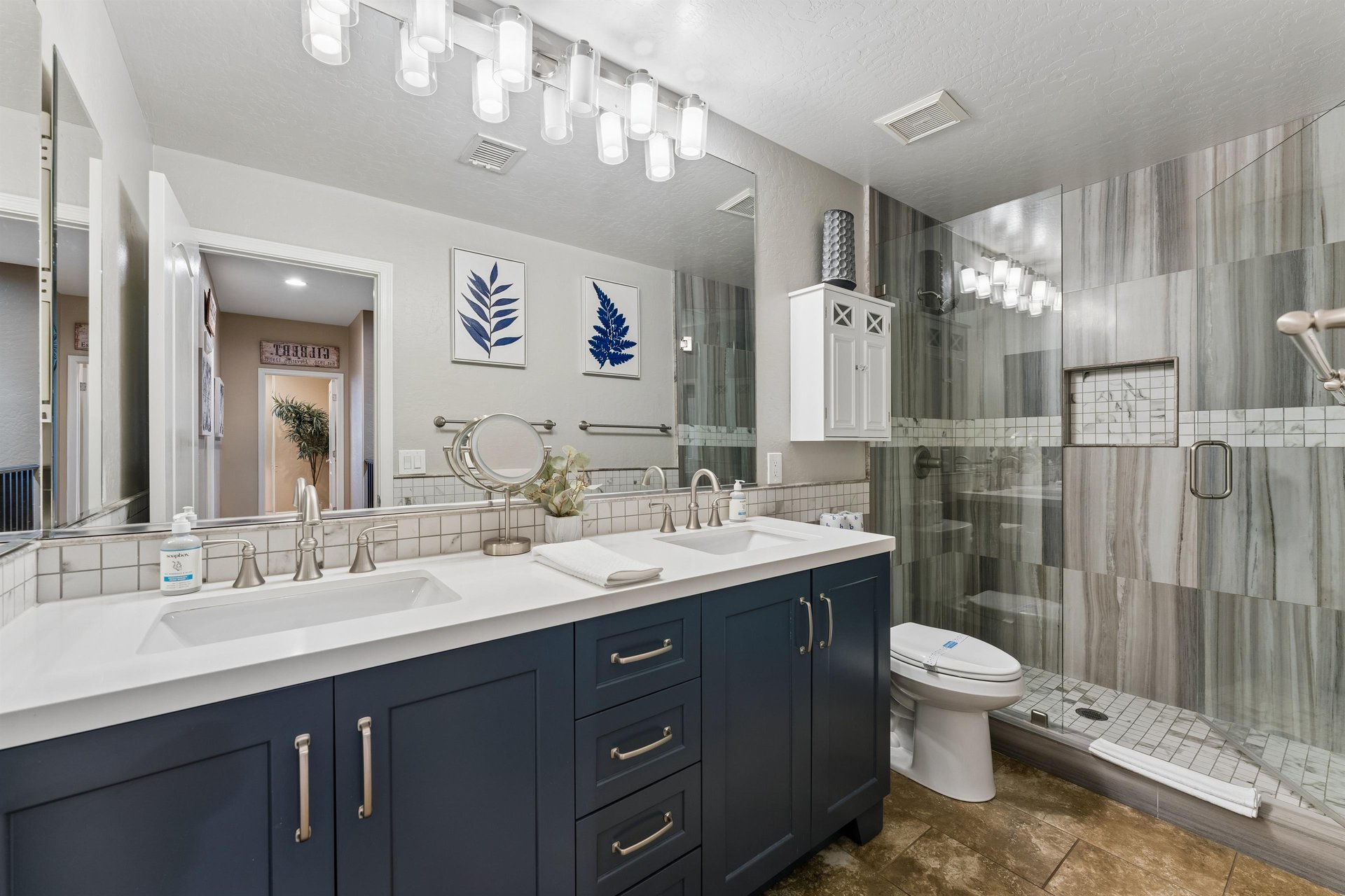 Dual vanity sinks, walkin shower, and modern finishes.