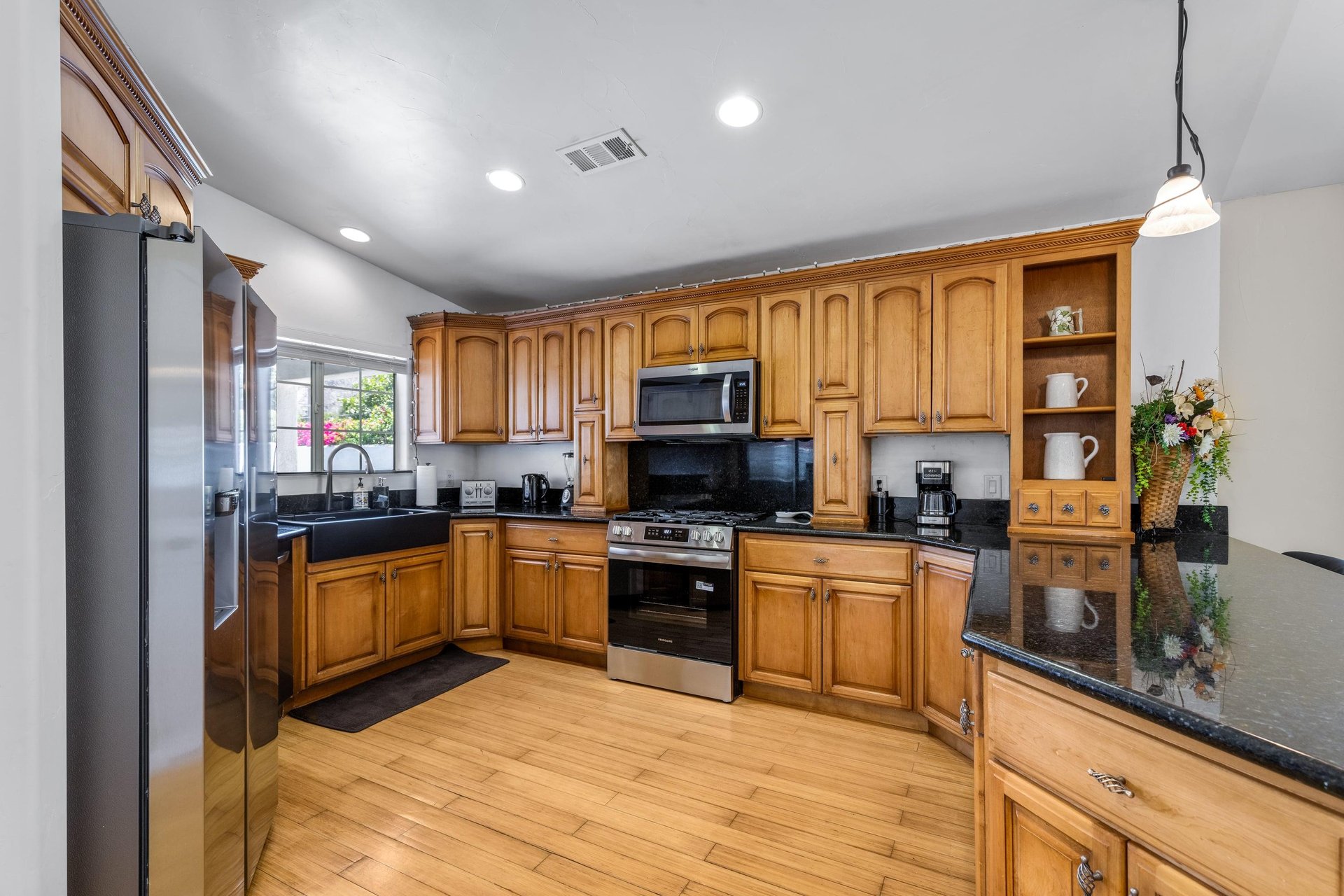 Stainless steel appliances, coffee maker, granite counters, and counter seating for 4 guests.