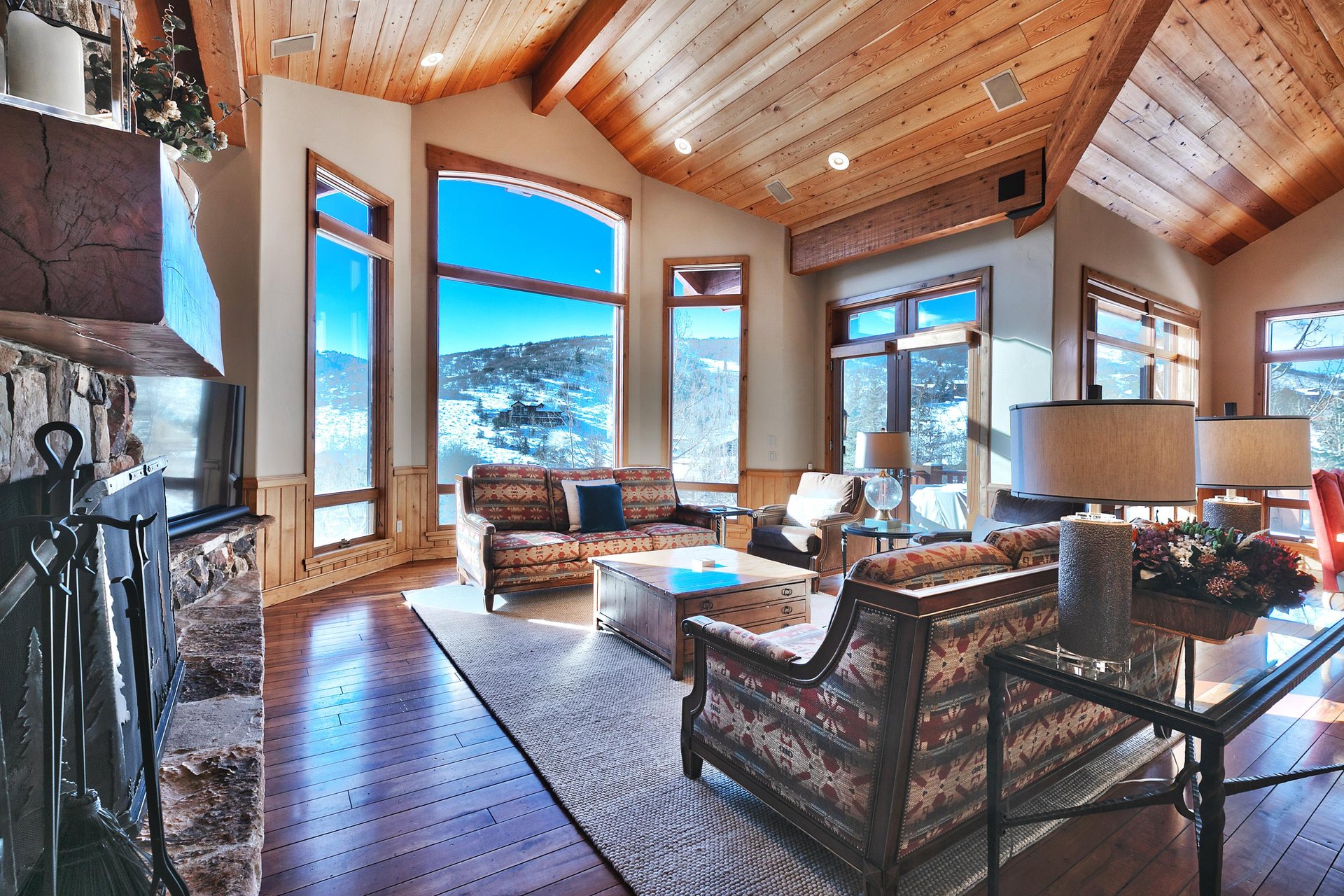 Expansive front room with stunning floor to ceiling windows, wood beams and ceiling and hardwood floors throughout.