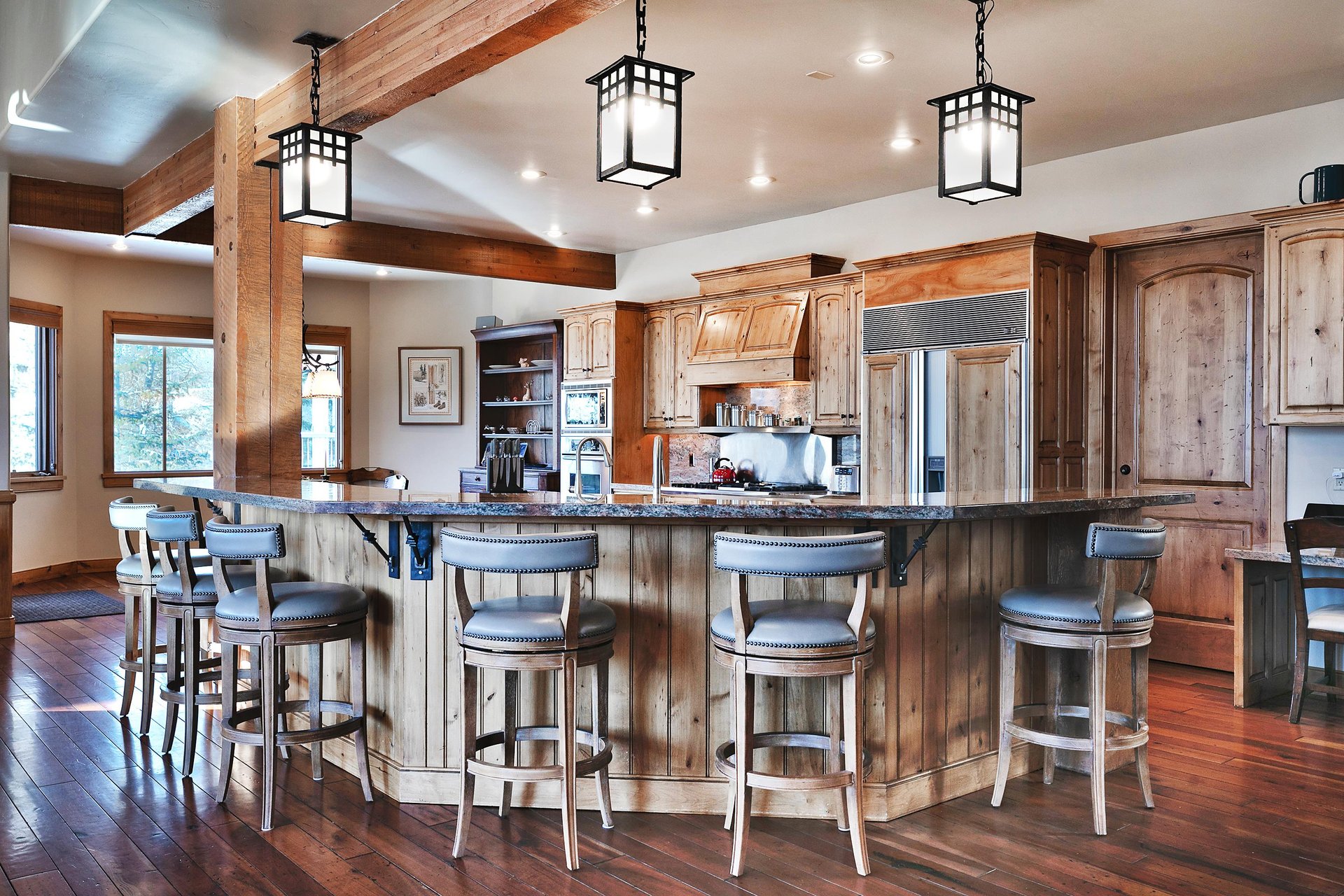 Two kitchen islandsone wrap around and one center island, both have sinks, medium wood cabinets, and granite countertops.