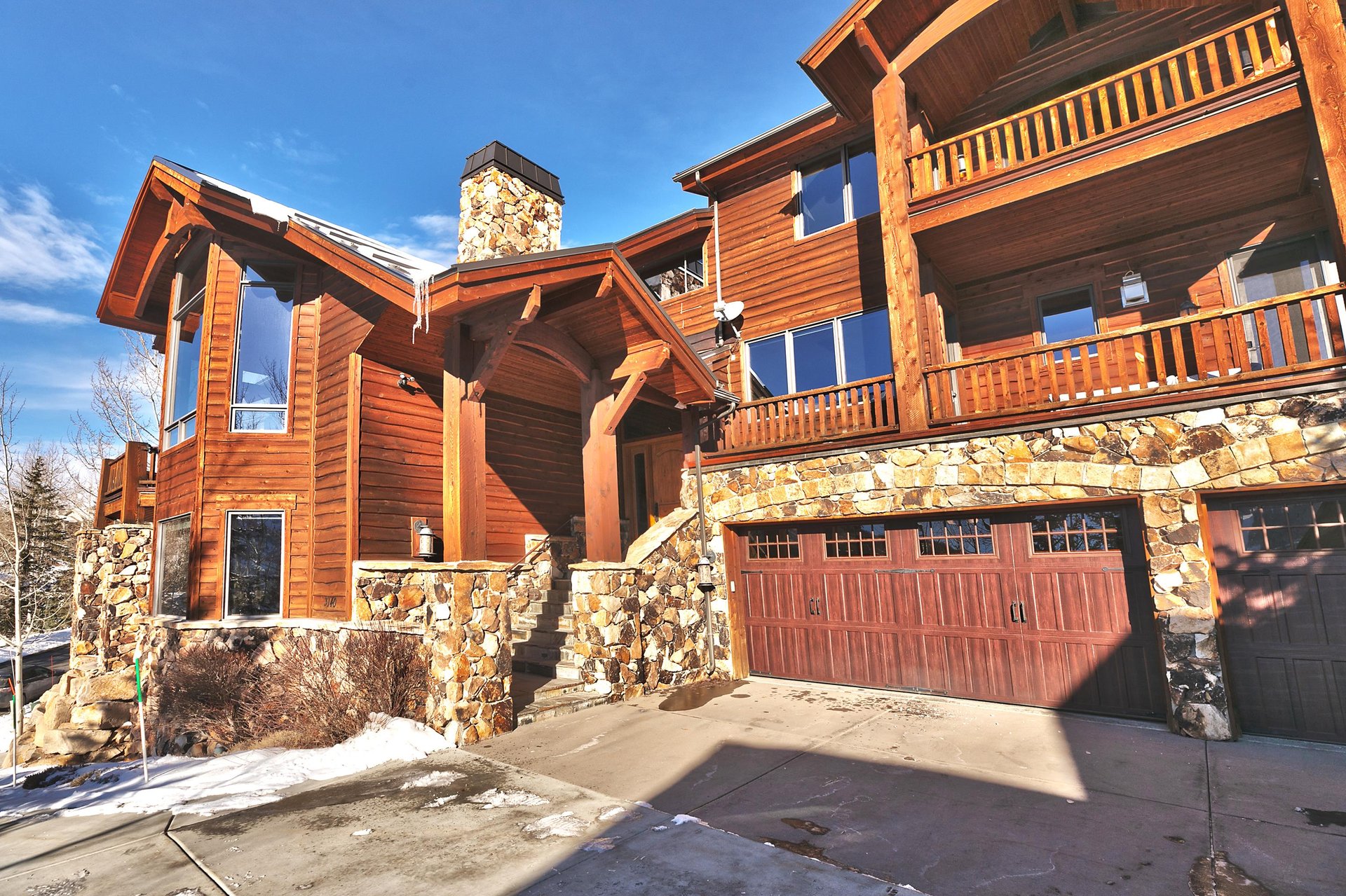 A private 2 car garage at Thistle Home, stunning stone and wood entrance, and wood and flagstone accents.