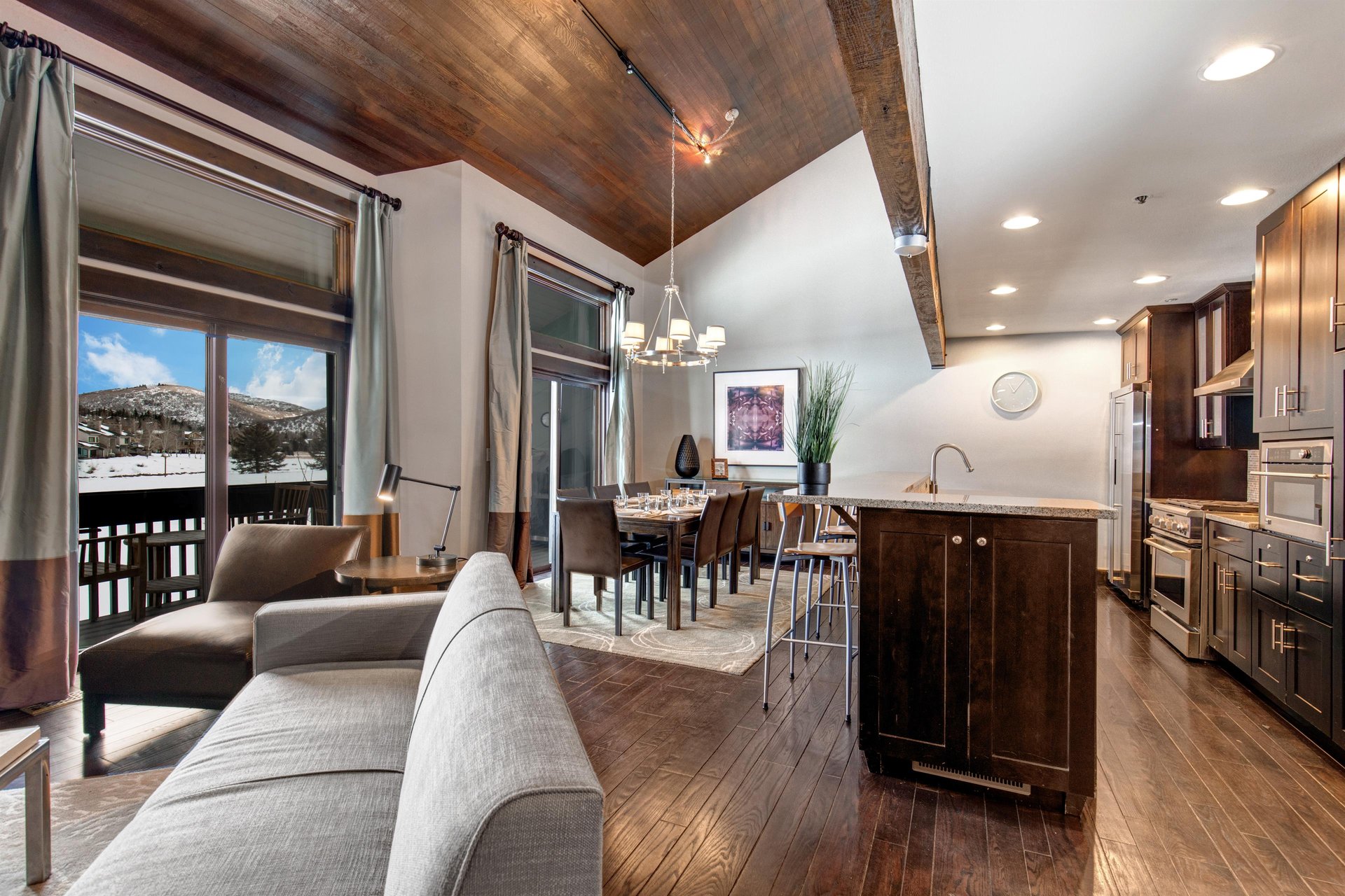 The open concept living room, dining and kitchen area with high ceilings.