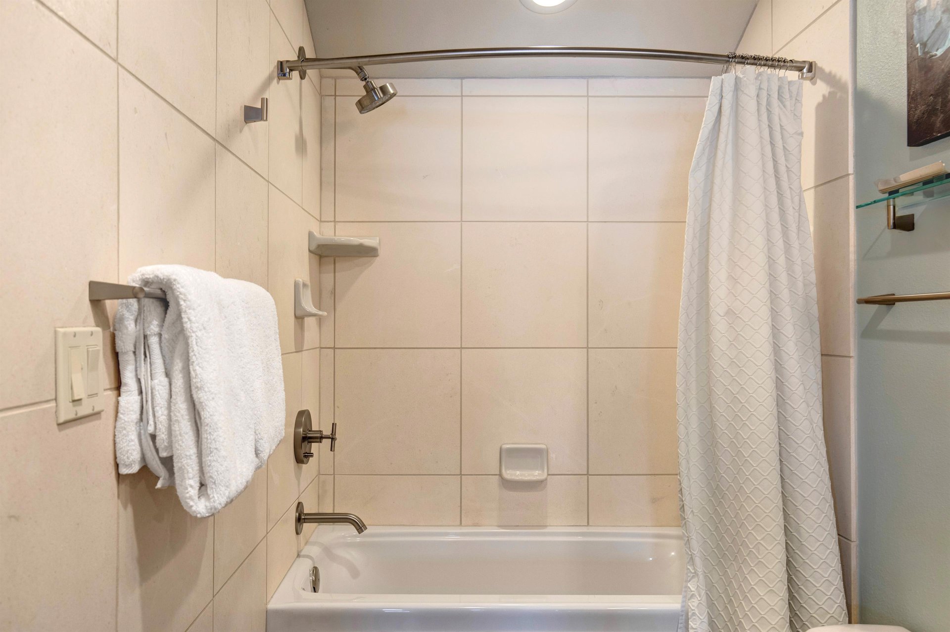The bathroom with a combination shower and bathtub.