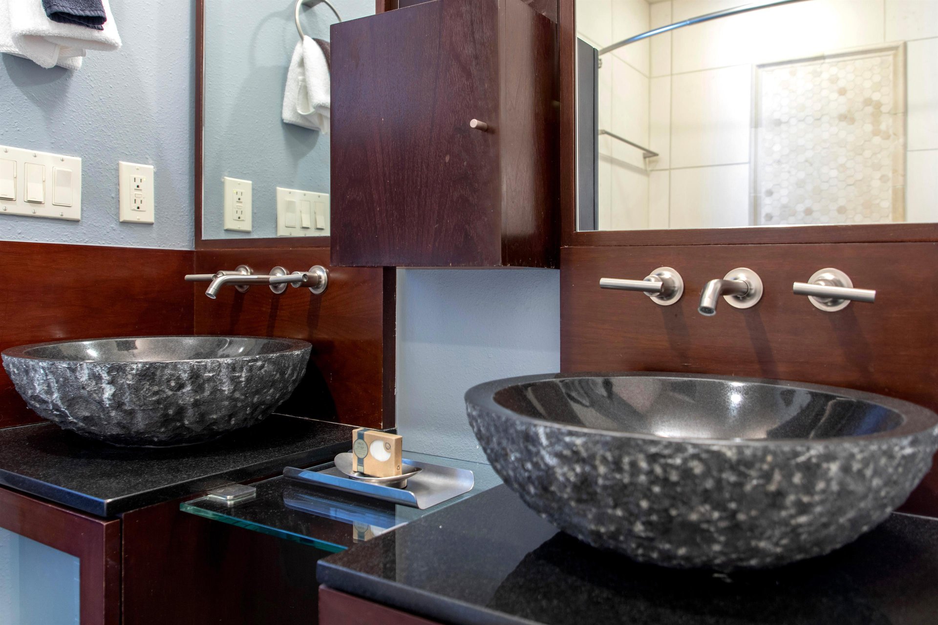The en suite bathroom has a two sink modern style vanity.