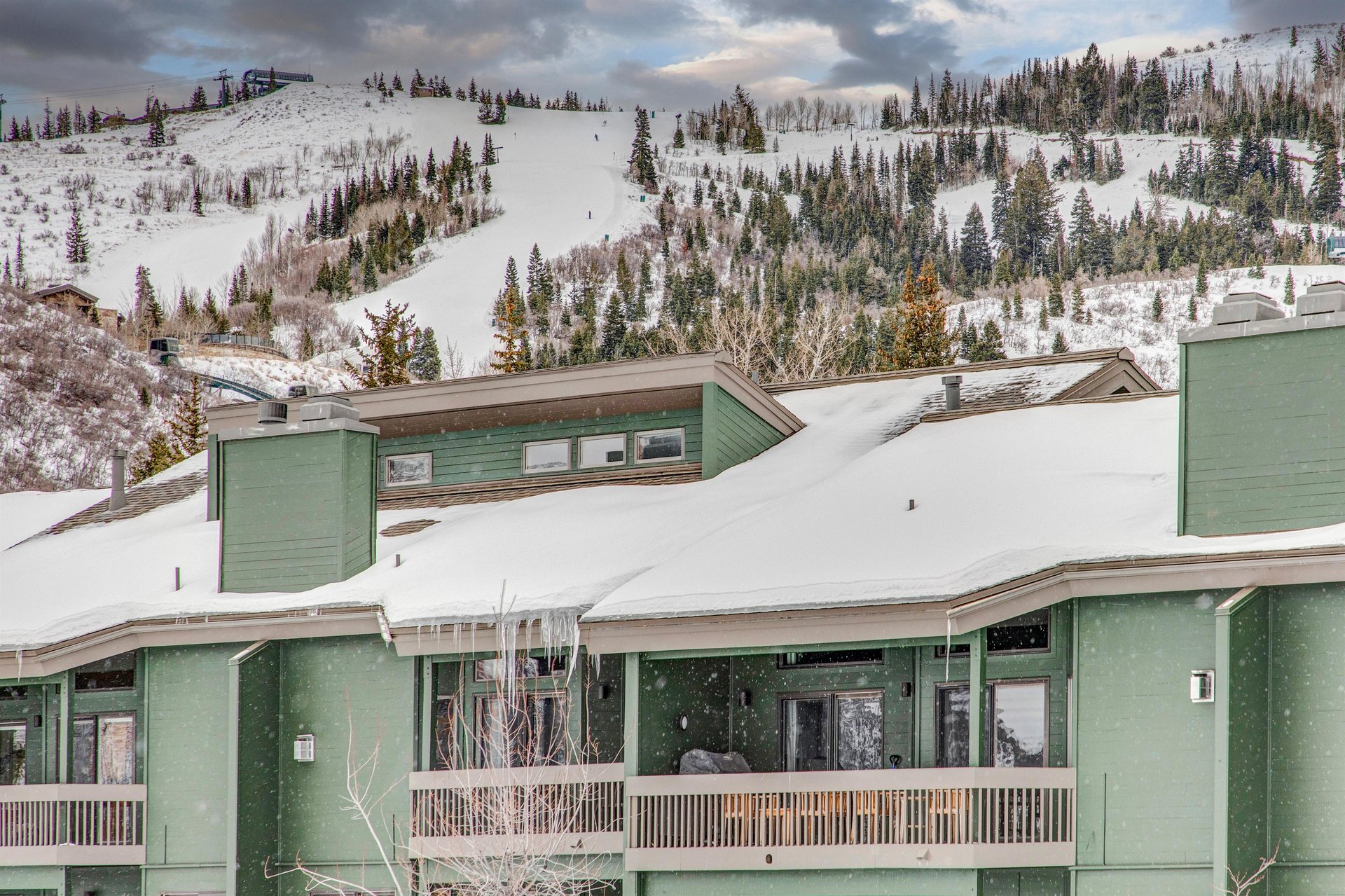 The exterior of the property with a snowy mountain behind it.