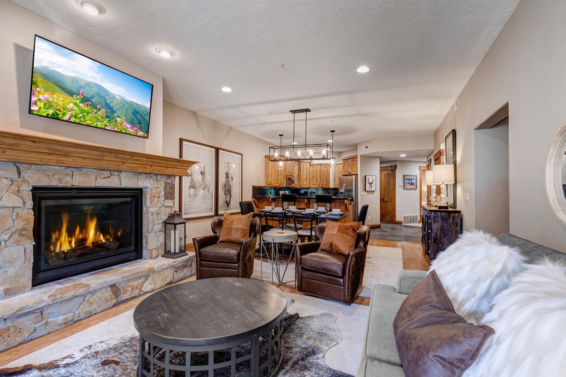 Relax in your spacious living room with a cozy stone fireplace, comfortable leather seating, and modern entertainment center  perfect for unwinding after a day of adventure.