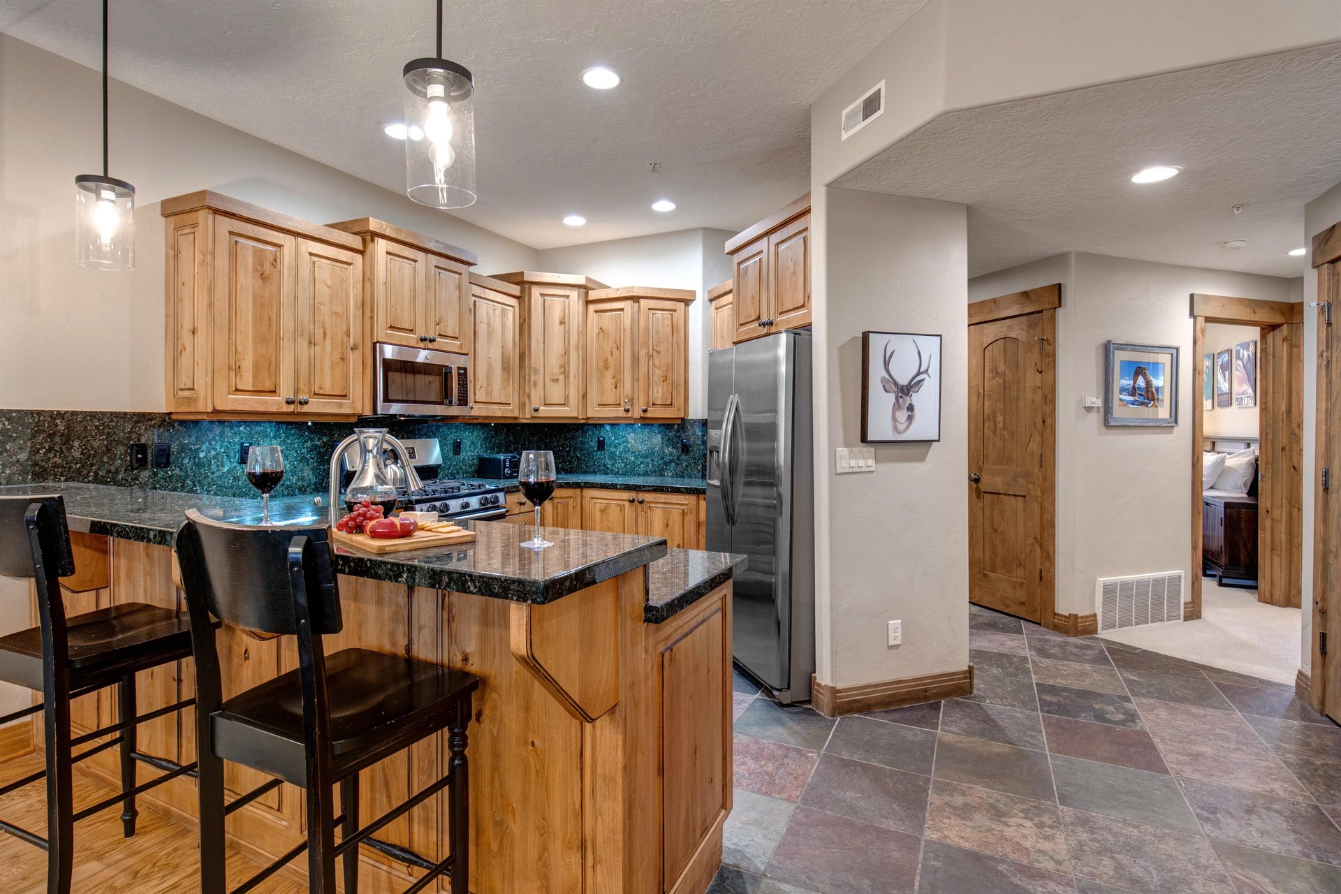 Your fully equipped kitchen features rich wood cabinetry, granite countertops, and modern stainless steel appliances  perfect for preparing meals during your stay.
