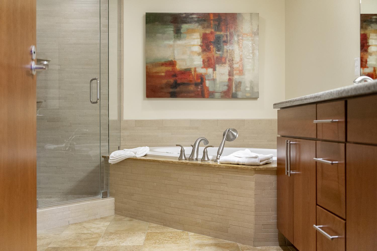 Extra large soaker tub next to the glass panel shower