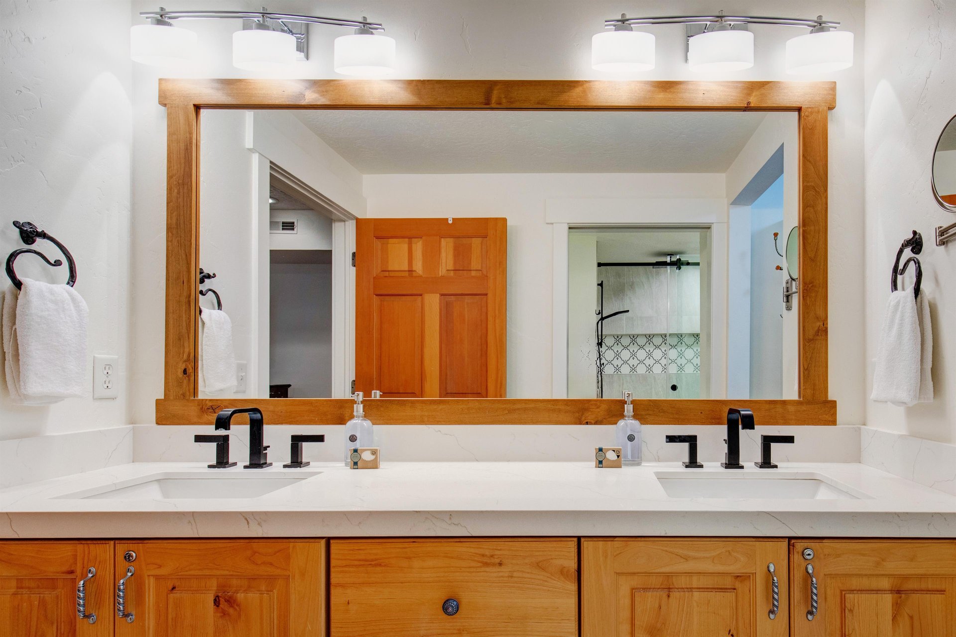 The en suite dualsink vanity features elegant marble countertops and custom wood cabinetry.