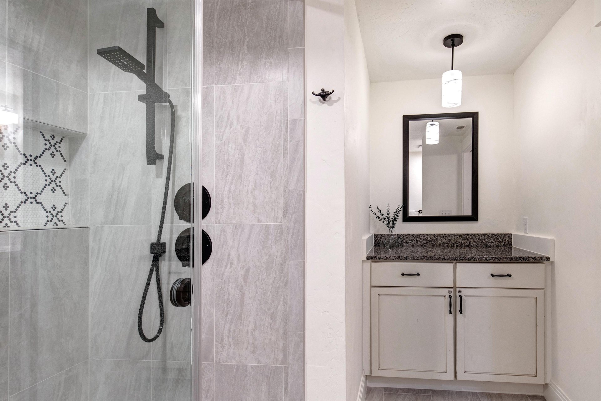 A sleek walkin shower featuring modern fixtures and elegant tiling, paired with a stylish vanity.