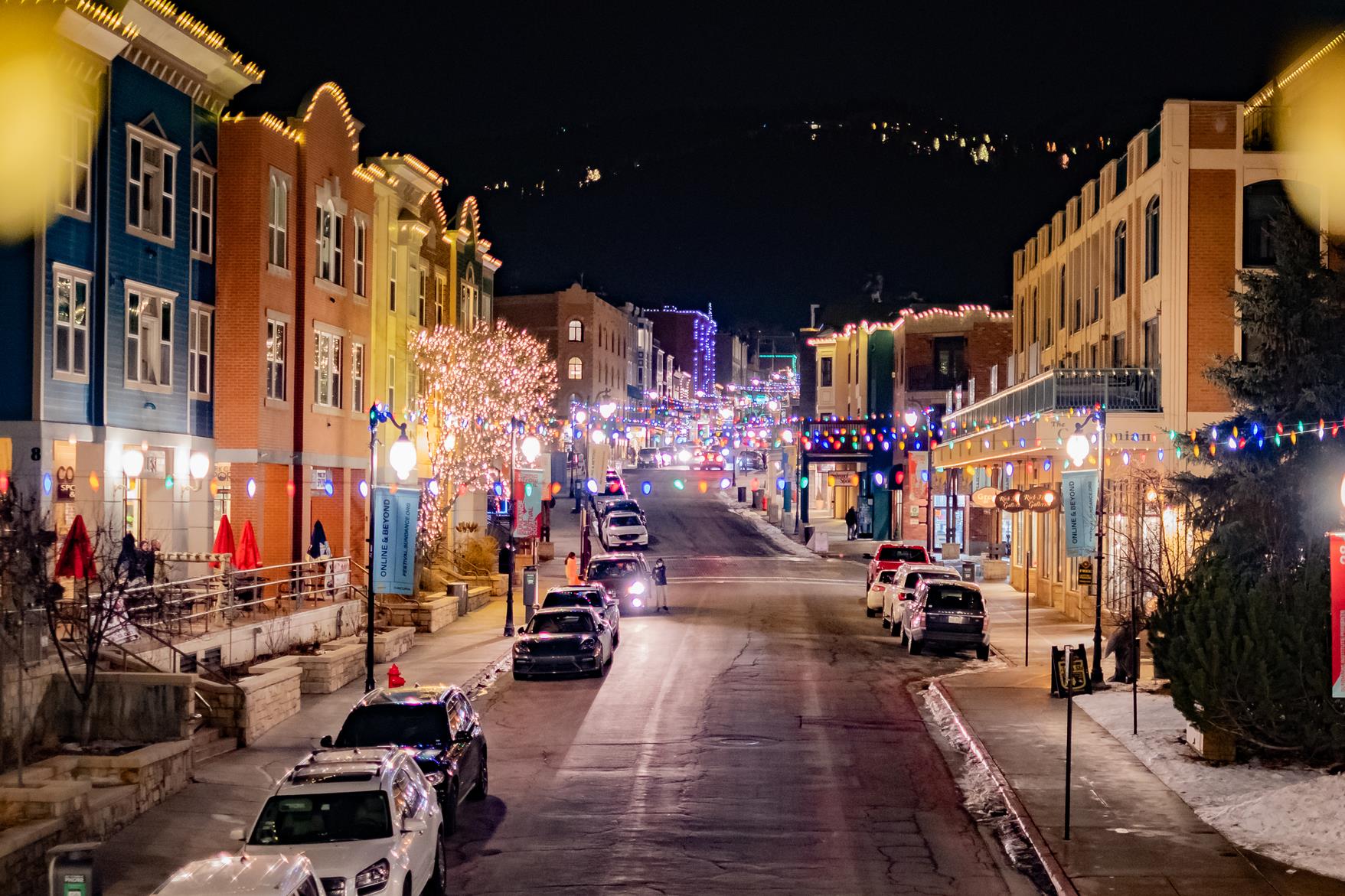 A vibrant street scene adorned with festive lights and colorful buildings creates a welcoming atmosphere in the surrounding neighborhood.