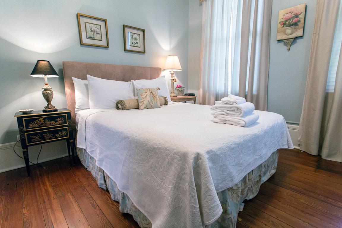At the top of the landing is a bedroom with a Queen bed with a luxury tufted headboard.