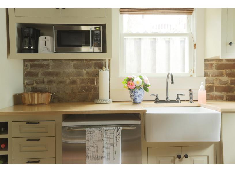 A beautiful farm house sink and bright cabinetry.