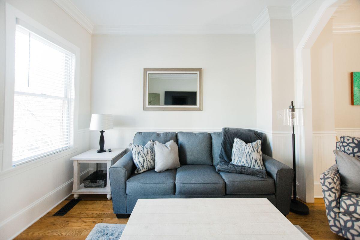 A plush grey sofa, with plenty of light for a afternoon read.