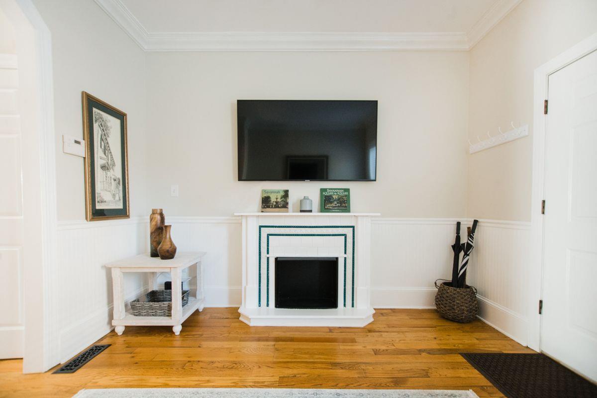 The large smart television has been mounted about the fireplace.