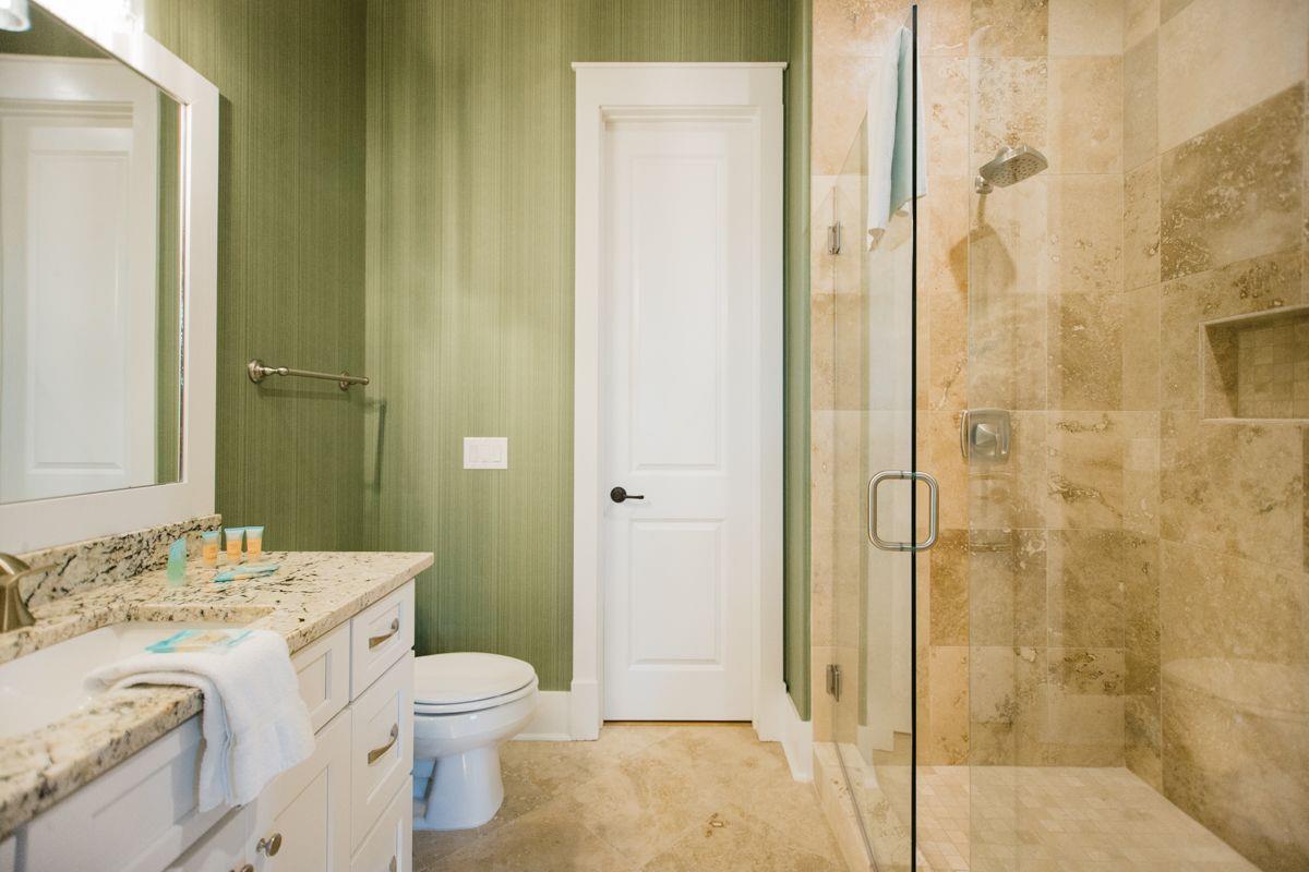 The en suite bathroom features a tiled walkin shower, and spacious vanity.