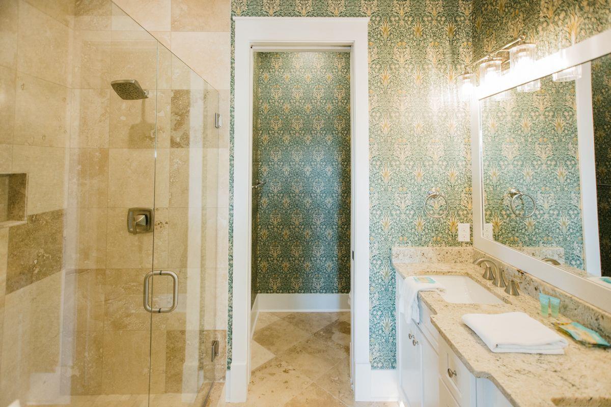 The en suite bathroom features a travertine tiled walkin shower.