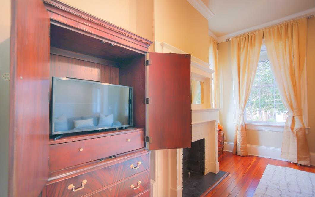 The flat screen television is located in the cherry wood armoire.