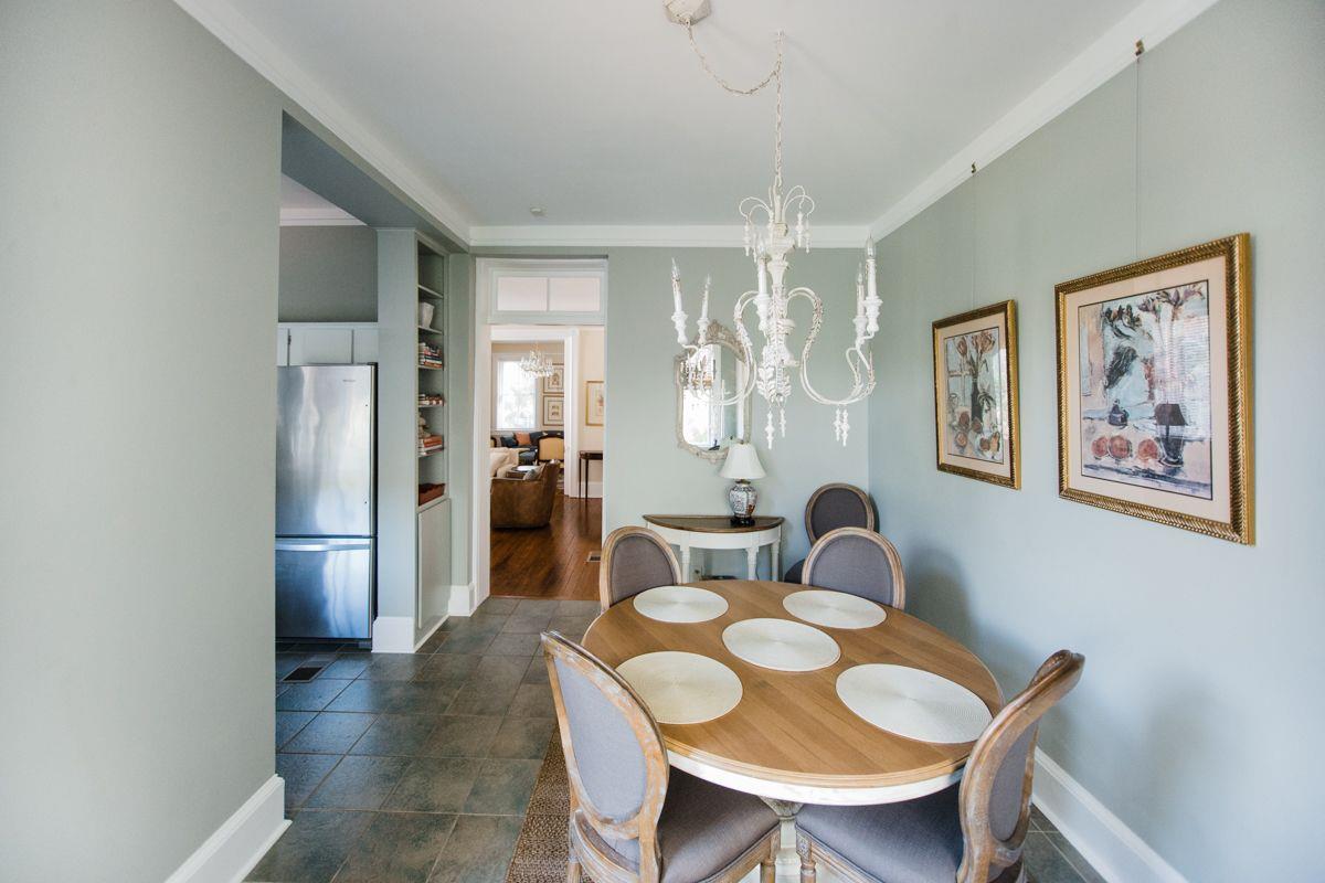 An antique chandelier hangs above the dining room table, and ties the space together.