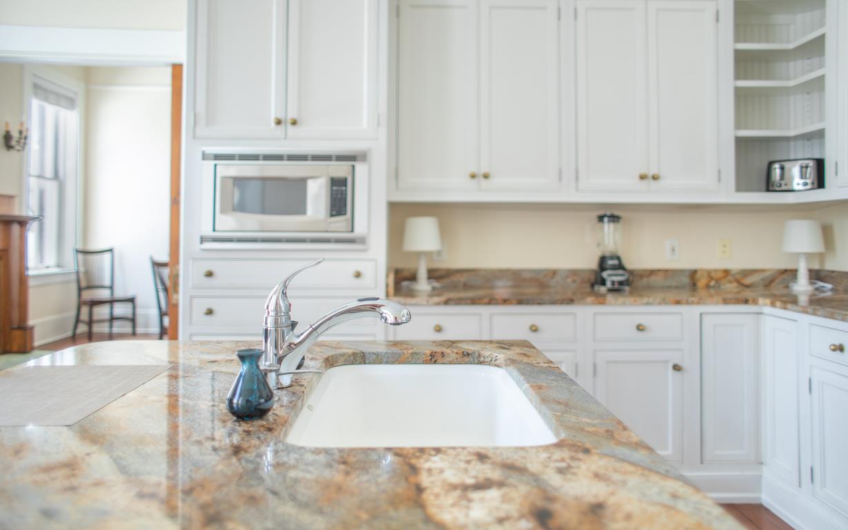 This kitchen has a stove, microwave, and full size fridge.