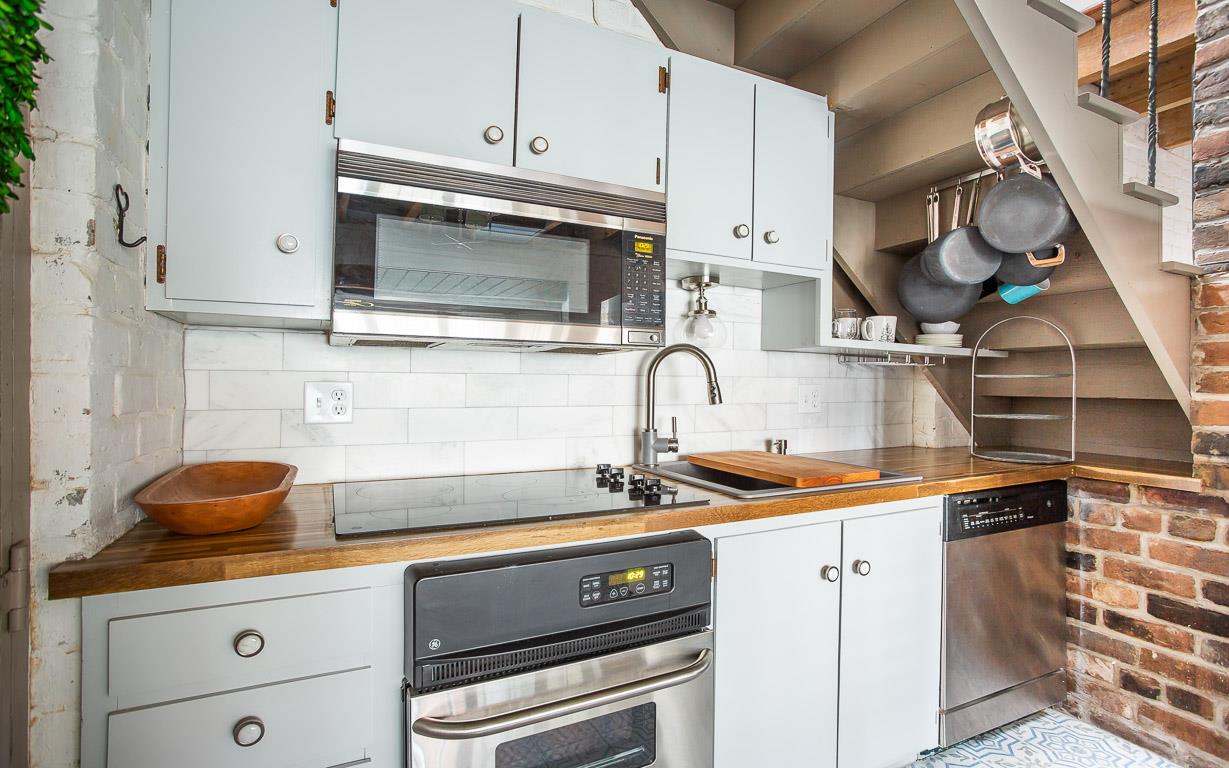 Exposed brick surrounds the kitchen, with a updated marble backsplash.