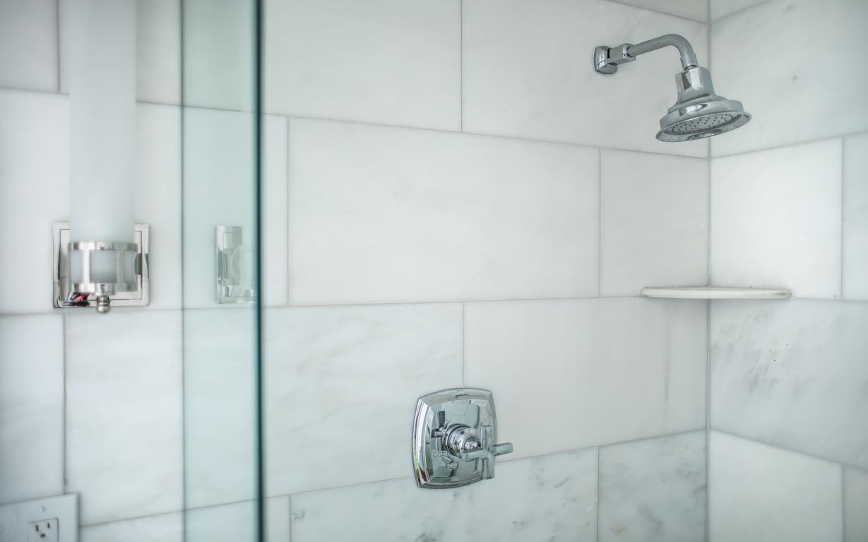 Standing shower with glass doors.