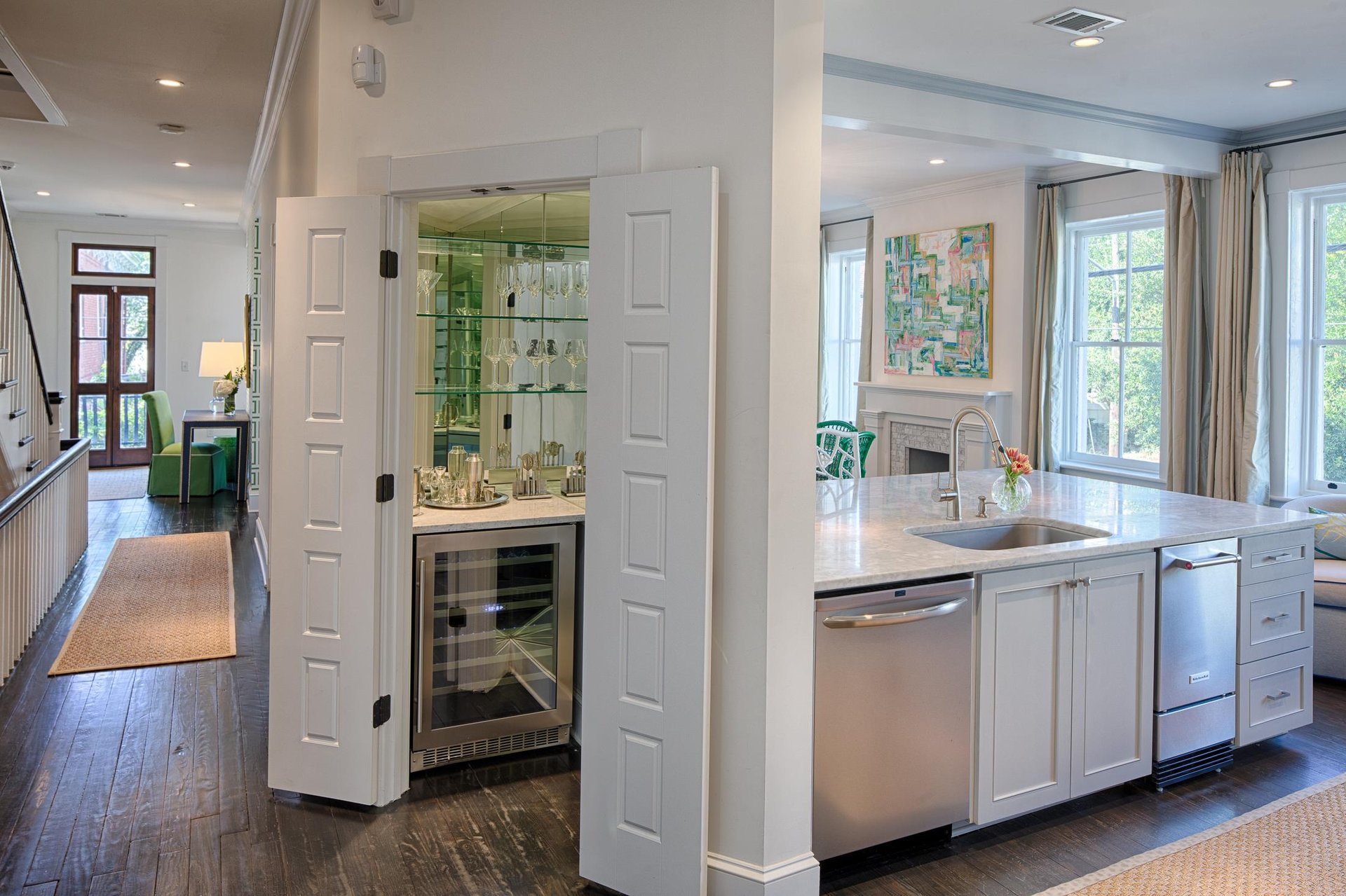 This custom bar is hidden right off of the kitchen, and features a wine chiller, in addition to everything needed to mix, shake, and prepare cocktails