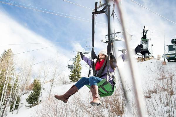 The Utah Olympic Park isnt just for Olympians — ride the freestyle zipline over stunning winter terrain just minutes from your Park City rental. Woman riding freestyle zipline at Utah Olympic Park in winter Park City Utah