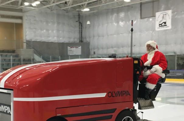 Santa traded his sleigh for a Zamboni — join us for Santa Skate at the Park City Ice Arena this winter. Santa Claus driving red Olympia zamboni at indoor ice rink Park City Utah
