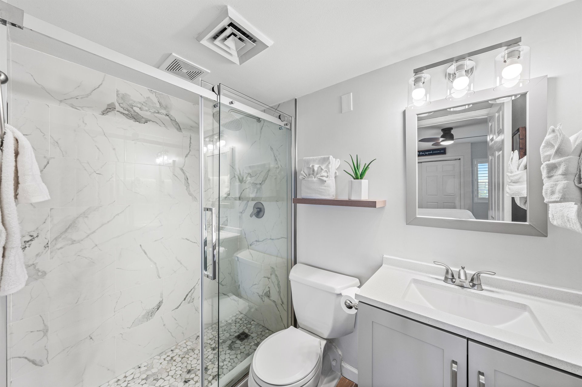 Newly renovated master bathroom with sleek vanity and spacious w