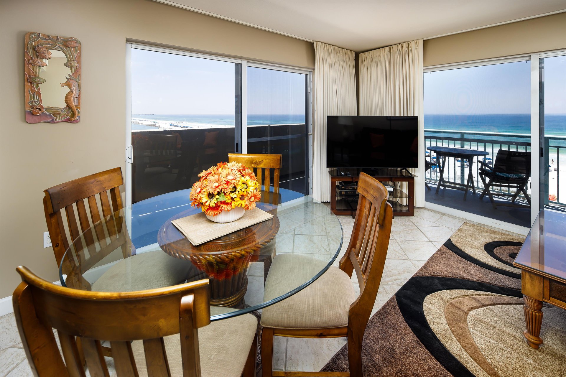 Dual sliding glass doors offer plenty of access to the wrap around balcony. Living room features a large flatscreen TV