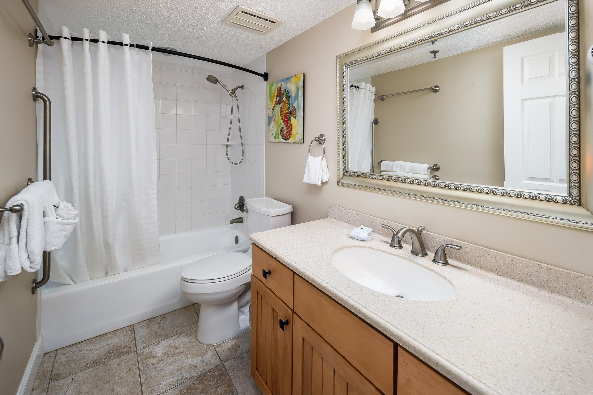 Brightlylit guest bathroom offers a full showertub combo perfect for a quick shower before a night on the town