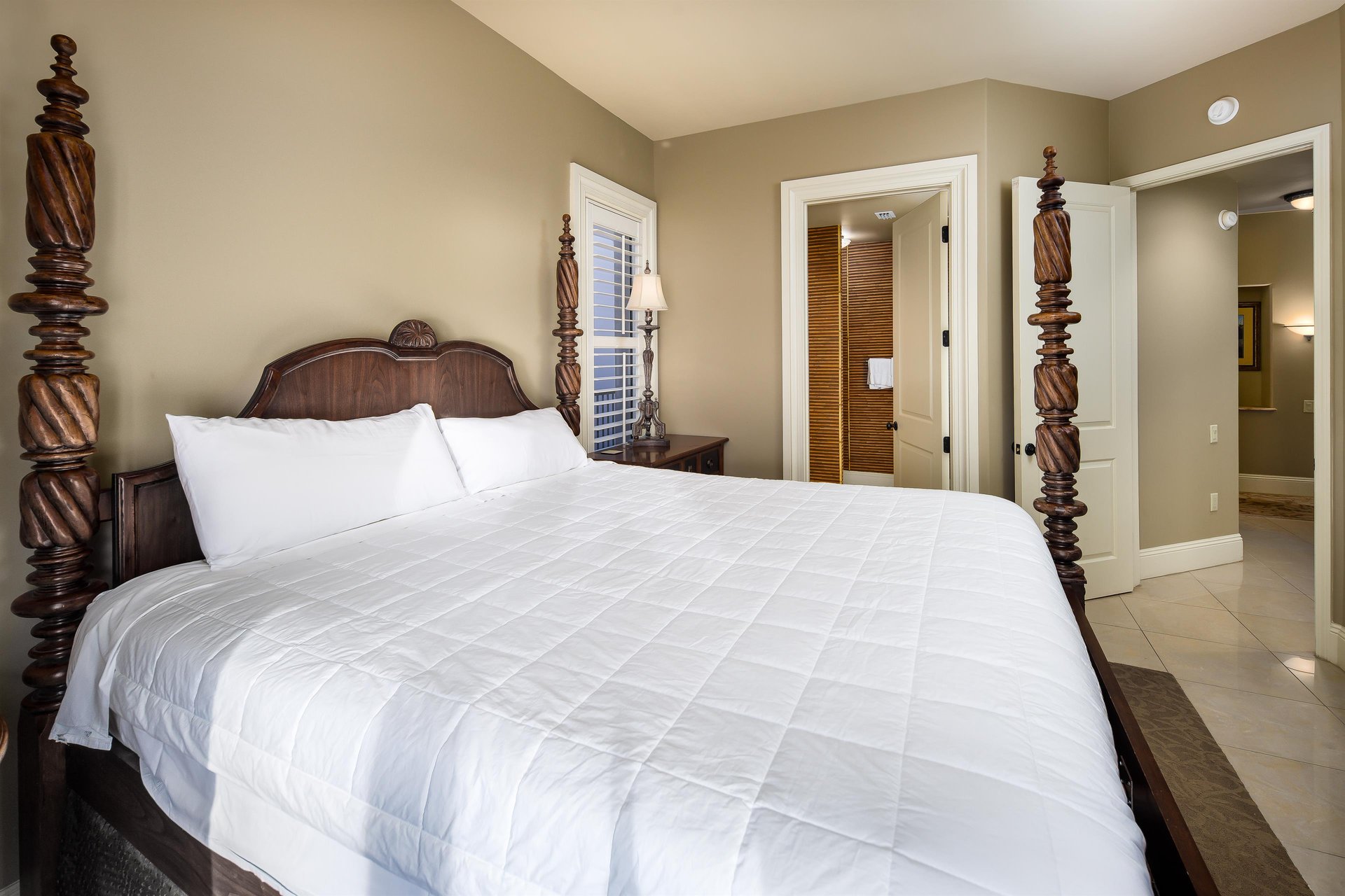 Intricately made dark wooden fourpost bed in the first guest bedroom reached after entry. It has everything LUXURIOUS for the ultimate guest experience.