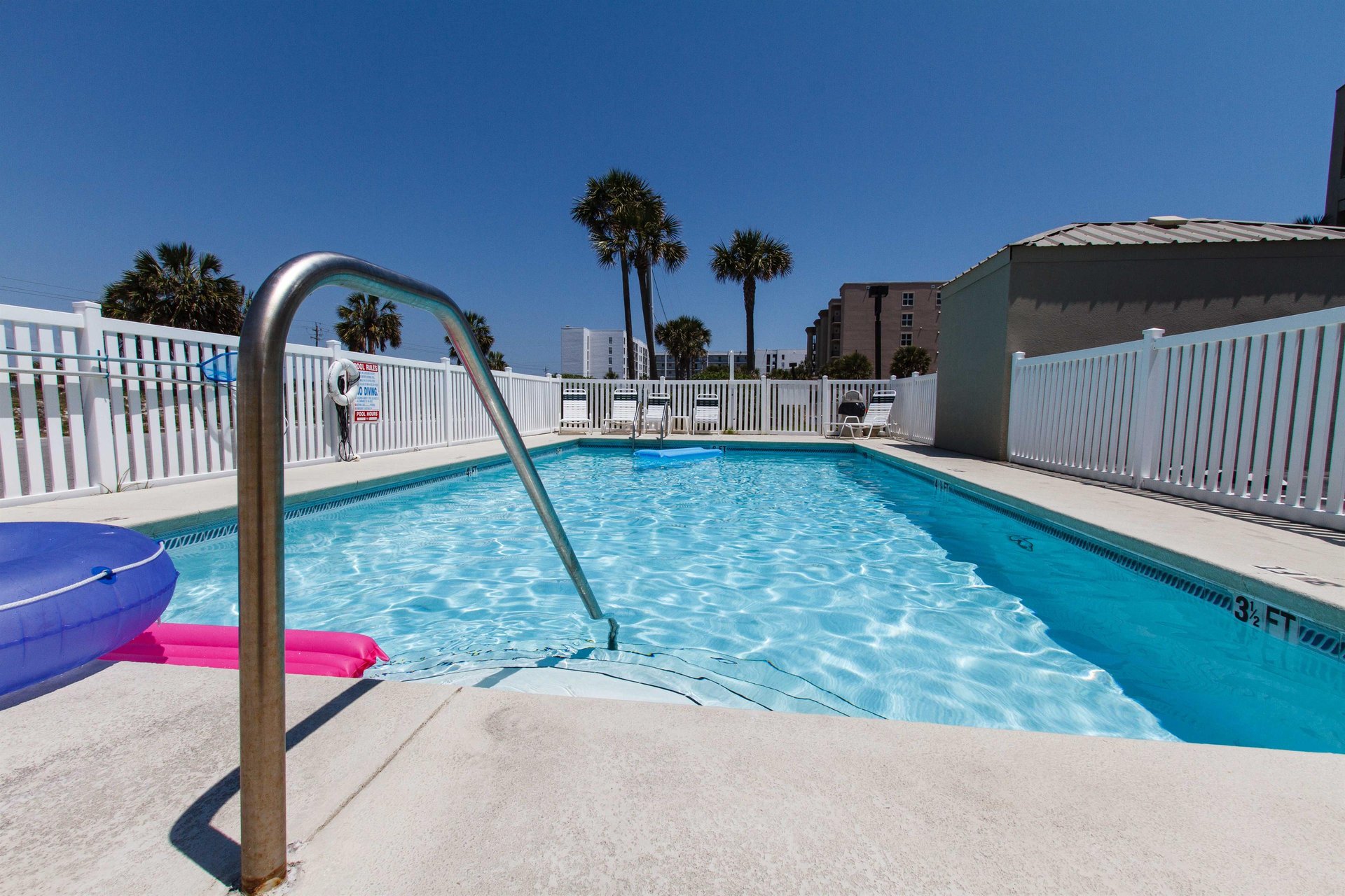 The fencedin pool is located in front of the buildings parking area. A small building next to it houses convenient bathrooms.