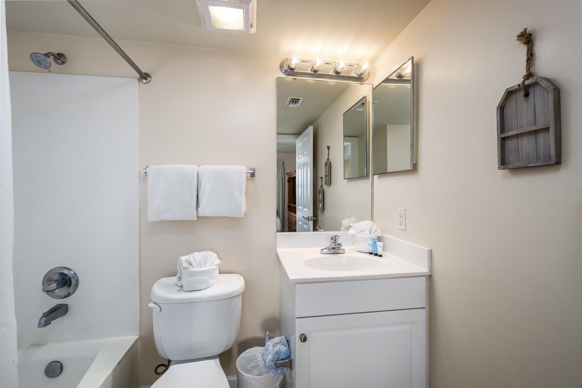 This bathroom has the tub  shower combo plus two mirrors.