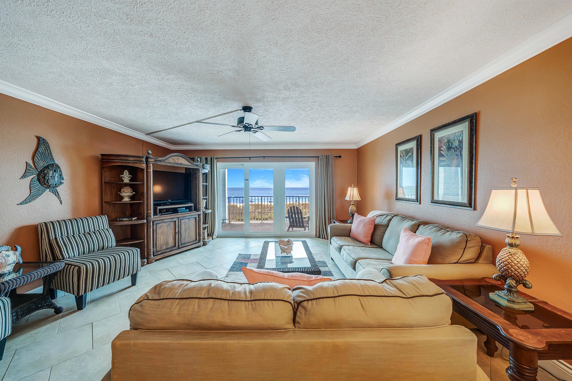 The living room offers ample, comfortable seating, a flat screen television, and beautiful views of the beach.
